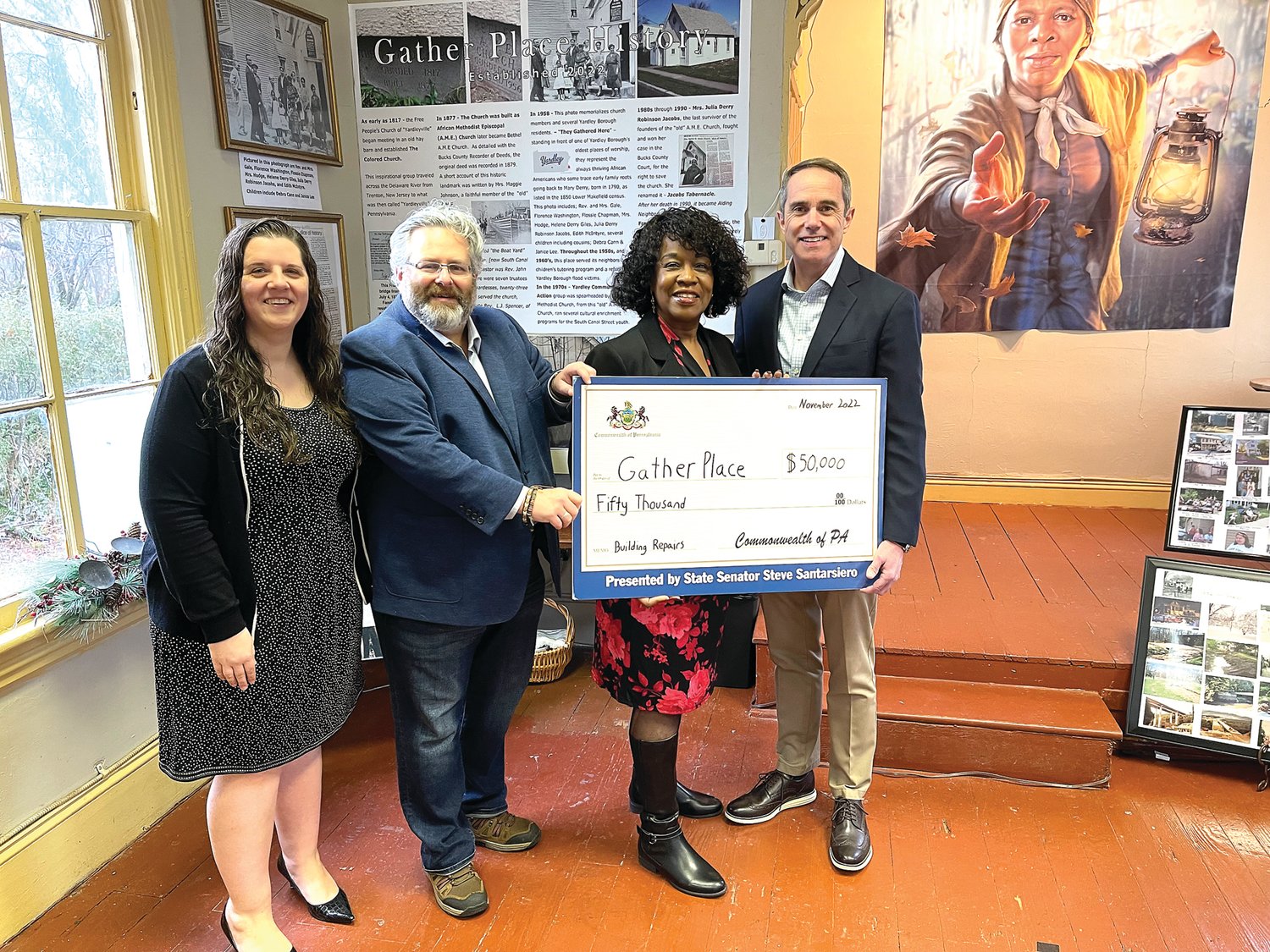 Shirley Lee Corsey, the founder of Gather Place, second from right, receives a ceremonial grant check from State Sen. Steve Santarsiero (D-10), right.
