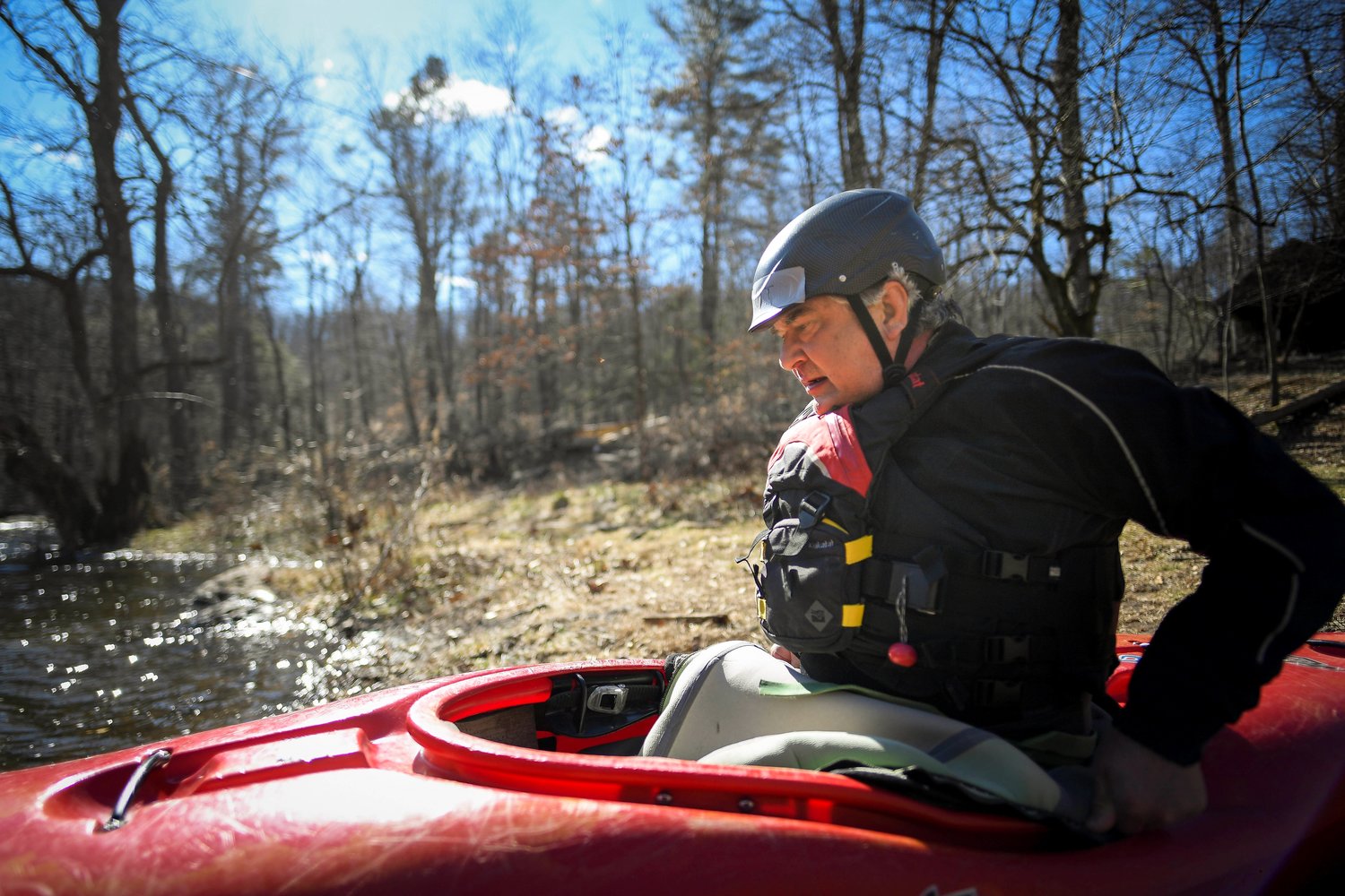 Scott Douglas of Springtown secures his waist rubber to the lip of the kayak before launch on March 19.