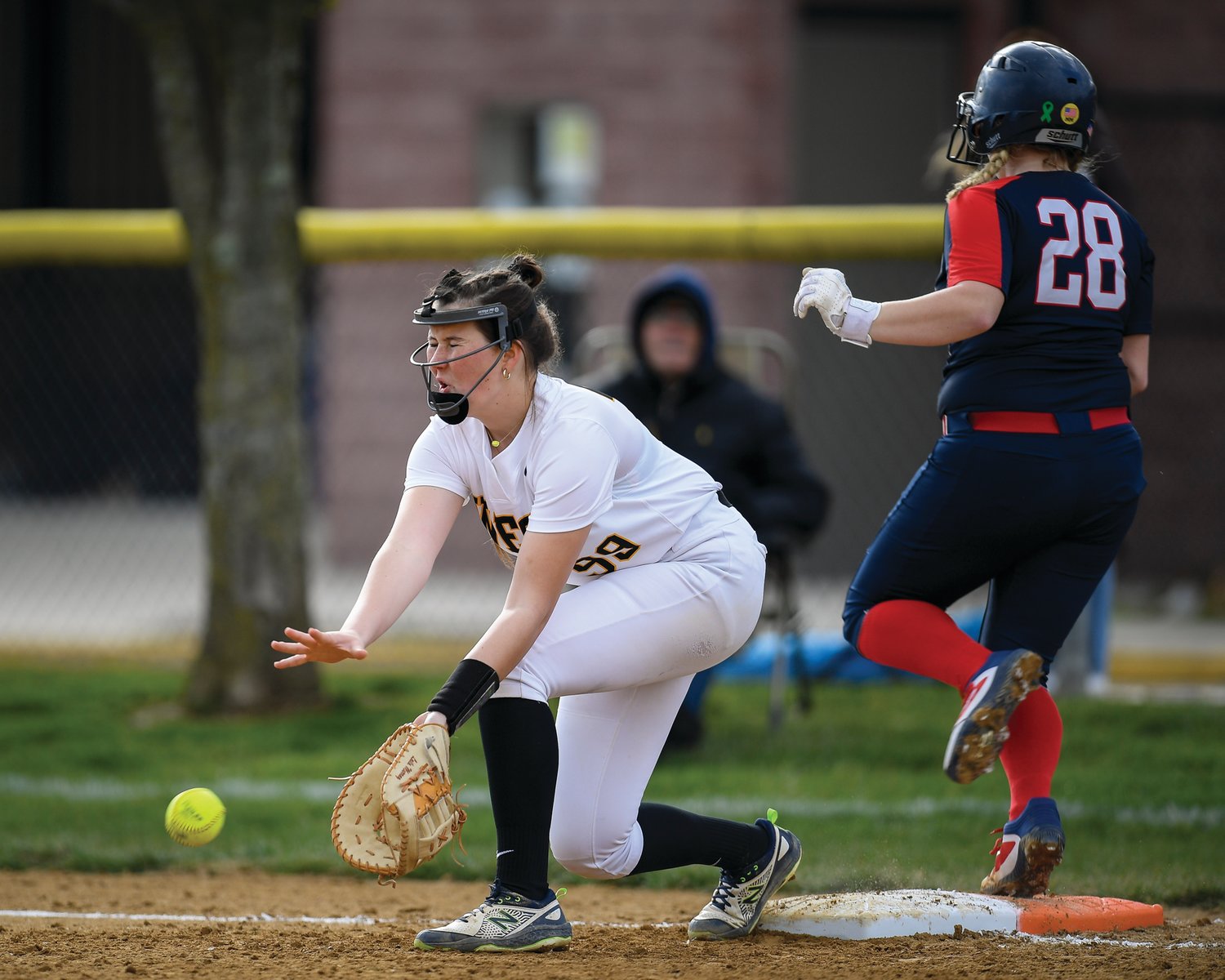 CB East’s Kayla Mitchell reaches base safely as CB West’s Laila Murray tries to dig out a throw.
