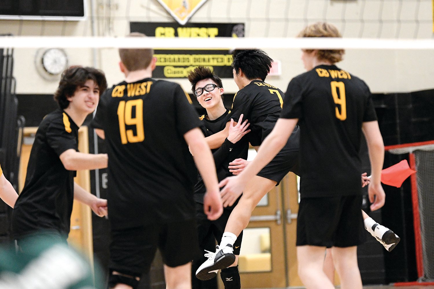 CB West’s Oliver Hu (in glasses) celebrates a point in the first set.