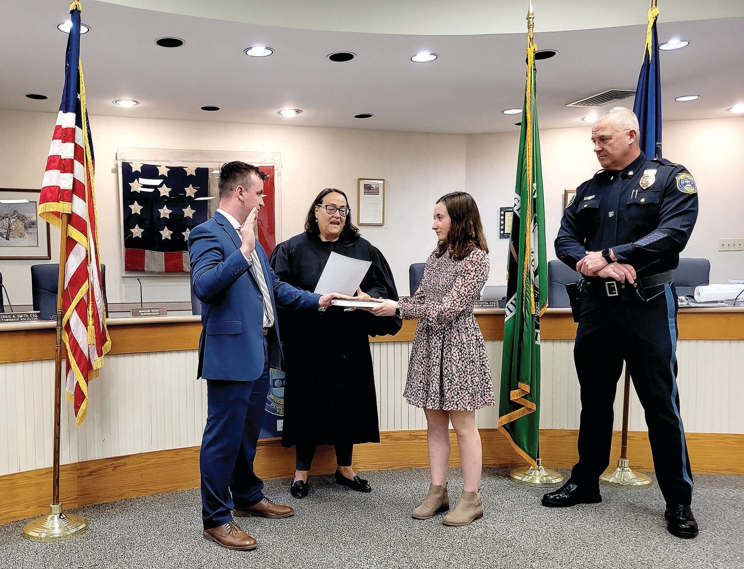 Buckingham Township Police Officer Emmett Shanks is sworn in by District Justice Maggie Snow at the March 22 supervisors meeting as a friend looks on.