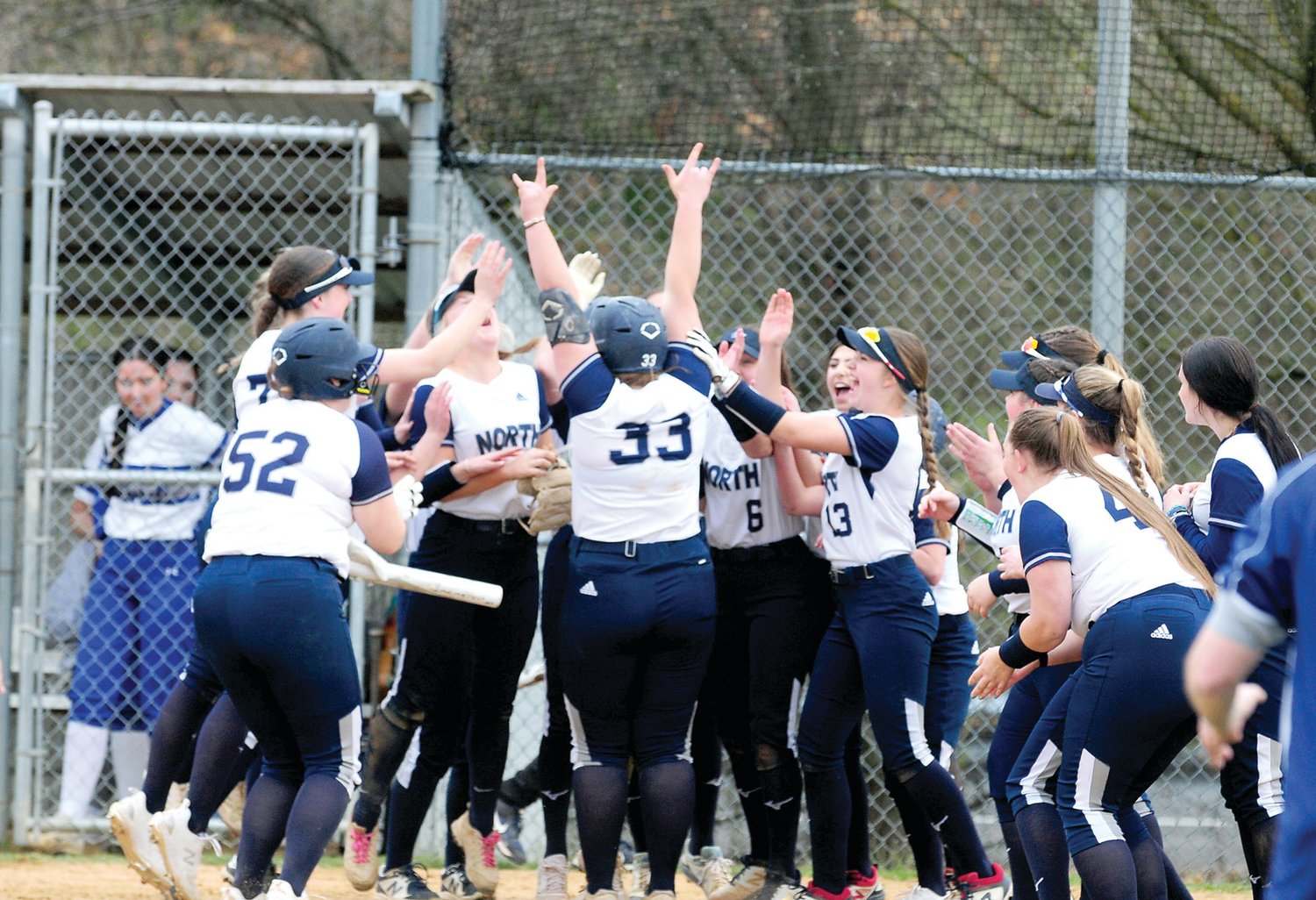 Council Rock North junior Molly Sheehy (No. 33) celebrates with her teammates at home plate after crushing a two-run home run to win a 6-5 battle with Villa Joseph March 31 on the Indians' home field.