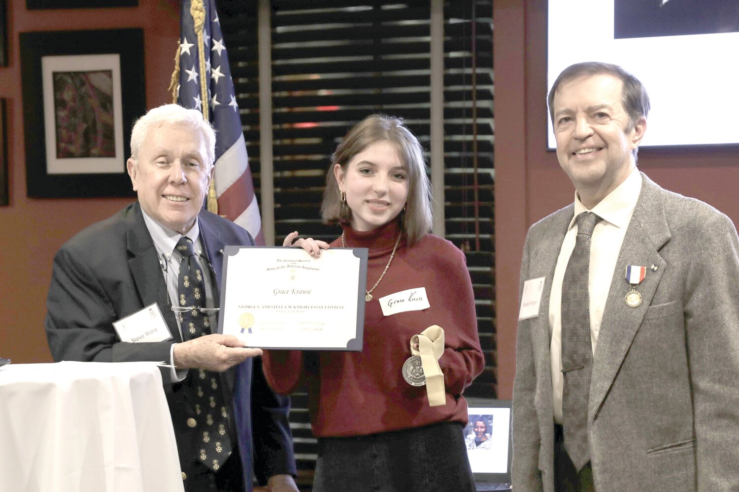 Washington Crossing Chapter Sons of the American Revolution First Vice President Steven Ware, Grace Krause, holding the Knight Essay Medallion and Certificate, and chapter President Robert Reiser.