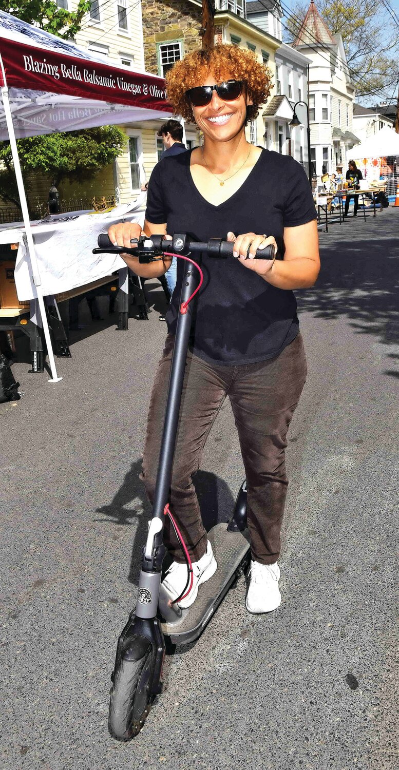 Janine LaBriola rides an electric scooter around Shad Fest.