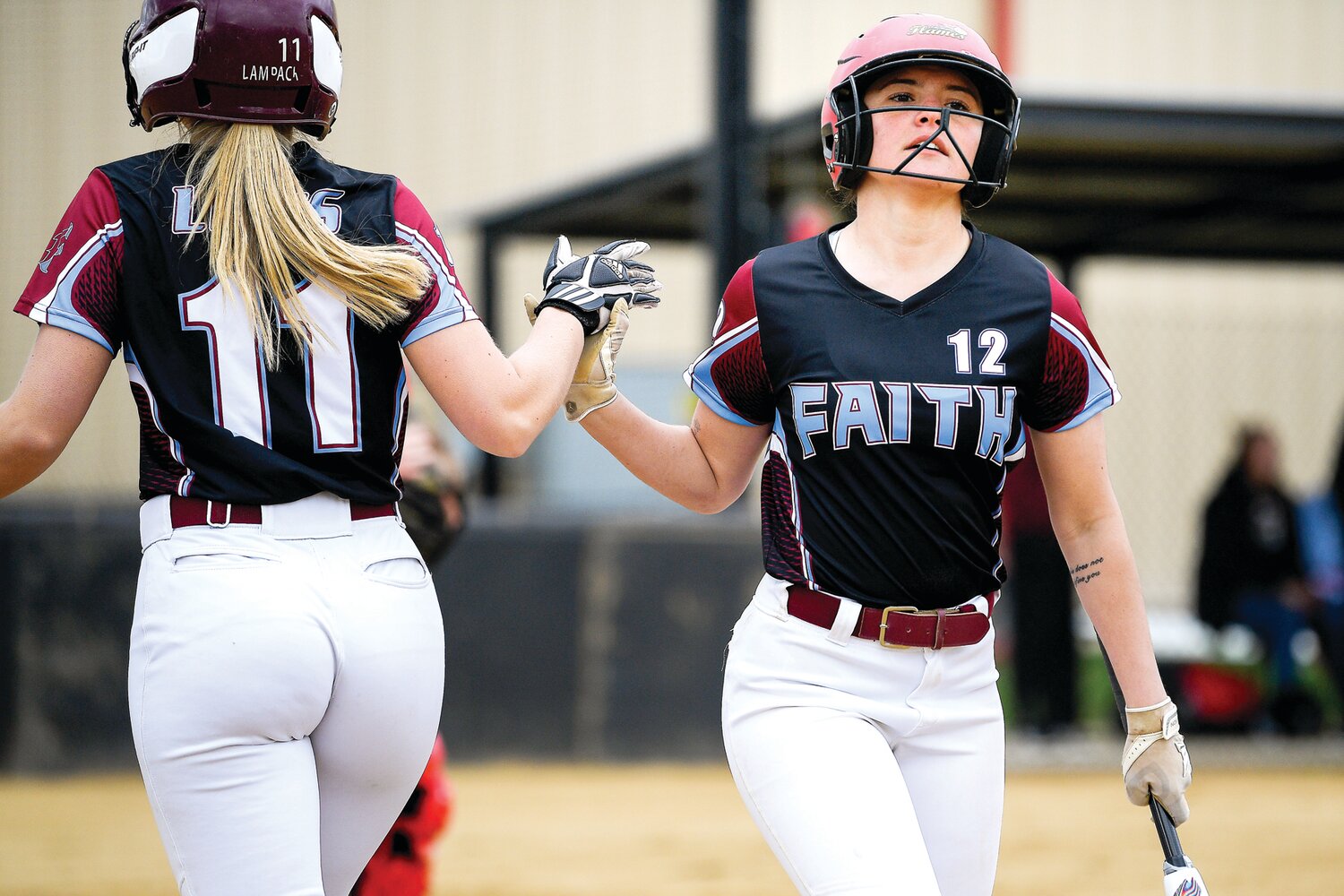 Faith Christian’s Jocey Heverly high fives Elana Ault during the 11-run first inning.
