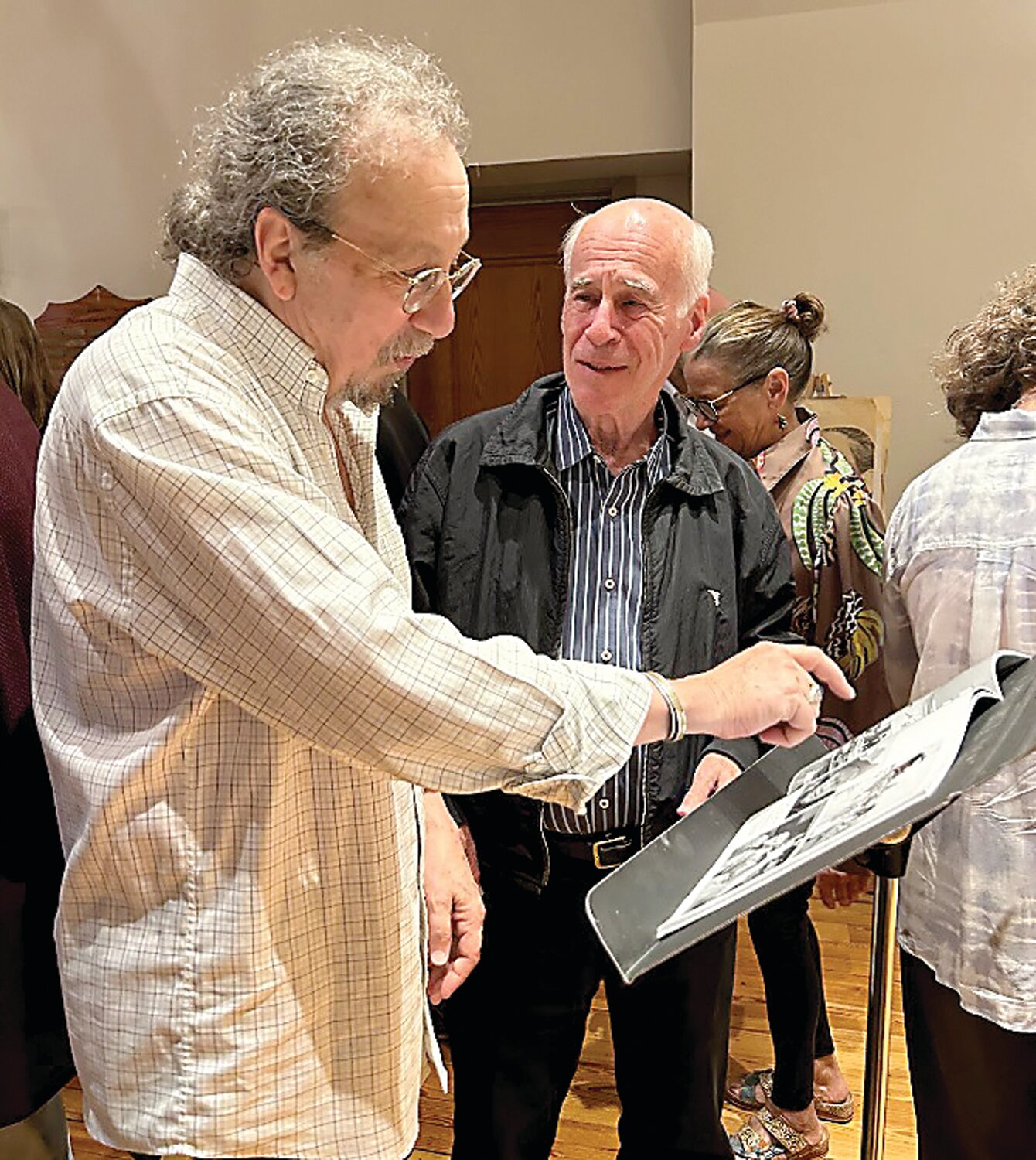 Rick Rosen (left) and Paul Murphy (right), owner of the former Sidetracks Art Gallery in New Hope, view the Jack Rosen Photography Book at a 100th birthday celebration in honor of the late New Hope photographer.