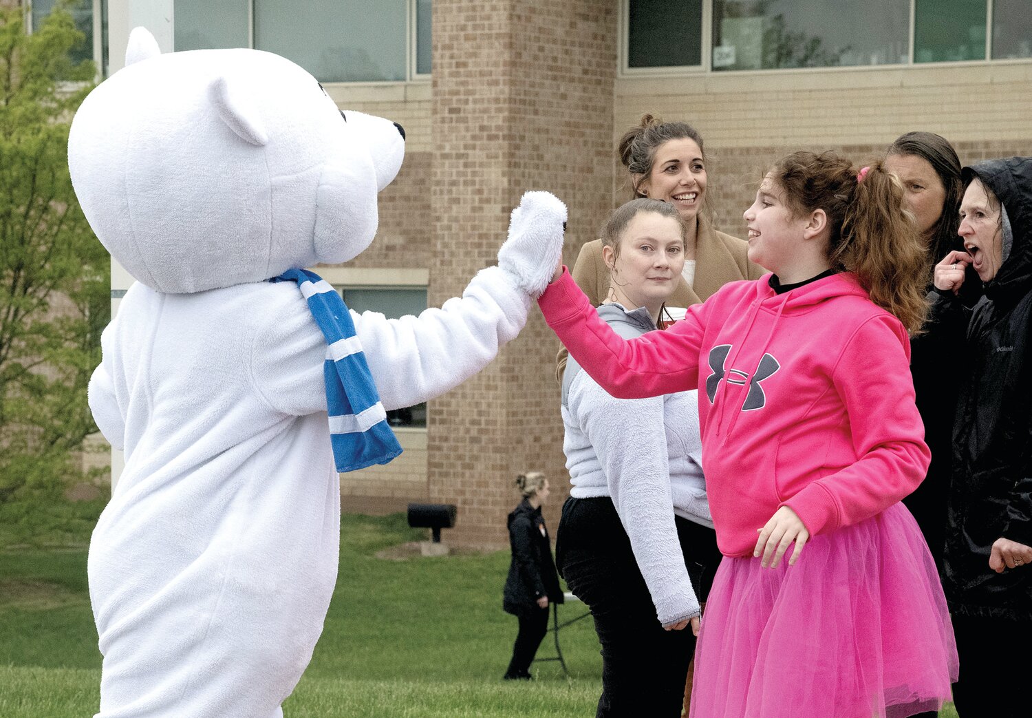 Kaya Devine gives a high-five to Chilly, the Special Olympics bear.