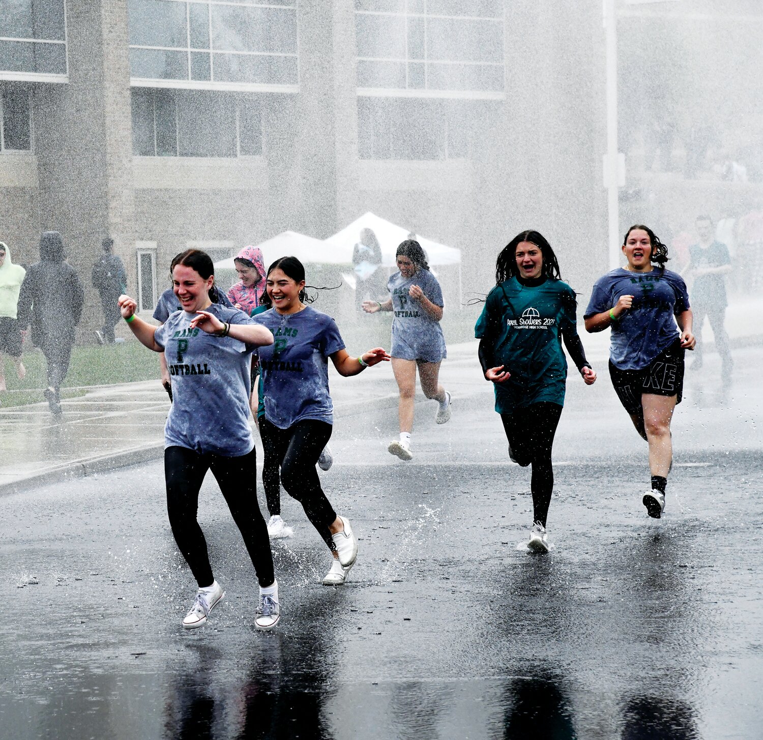 Students race through a deluge of water.