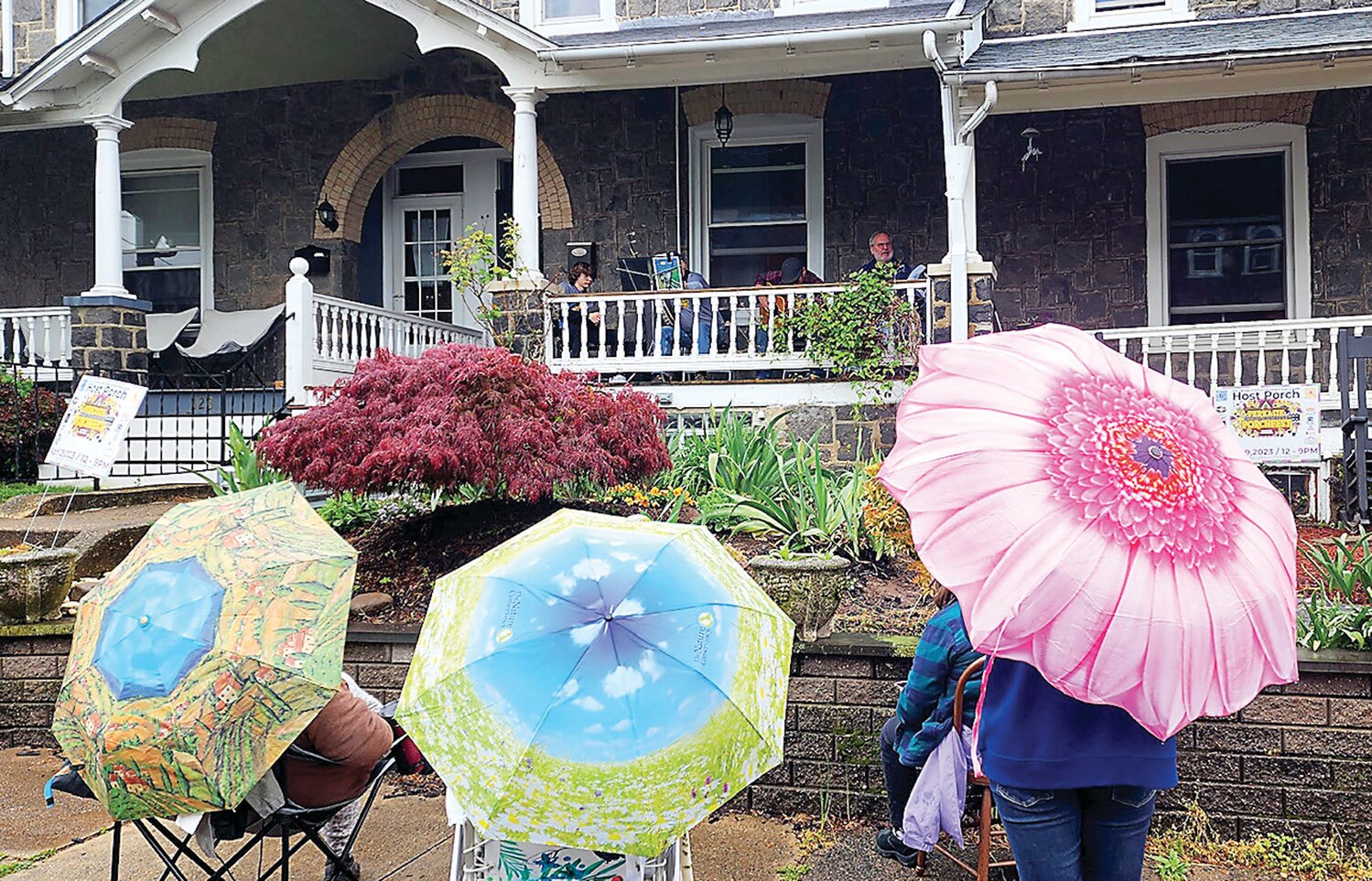 Music fans gather under their umbrellas to watch a Perkasie Porchfest concert.