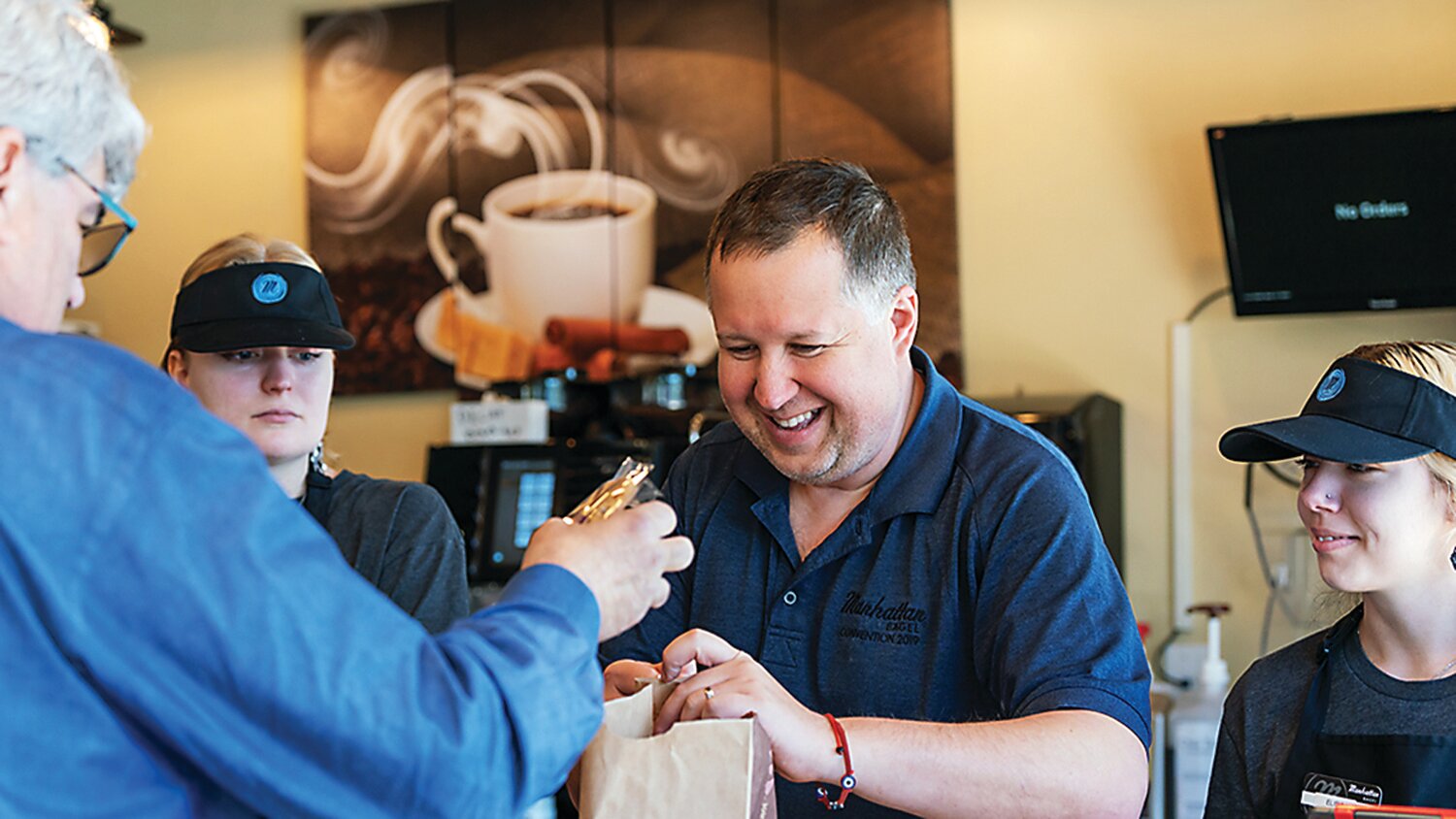 Ross Gelman helps a happy Manhattan Bagel customer.