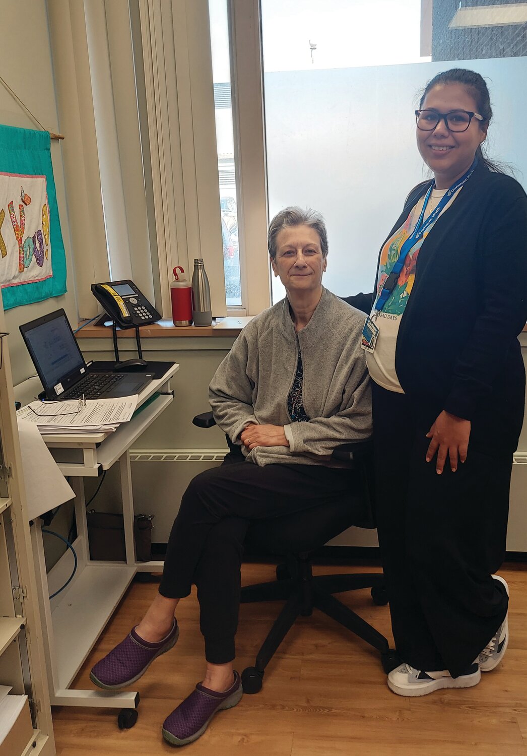 Diane Sarti, volunteer, and Fernanda Arceo Rojina, receptionist, work in the patient registration office.