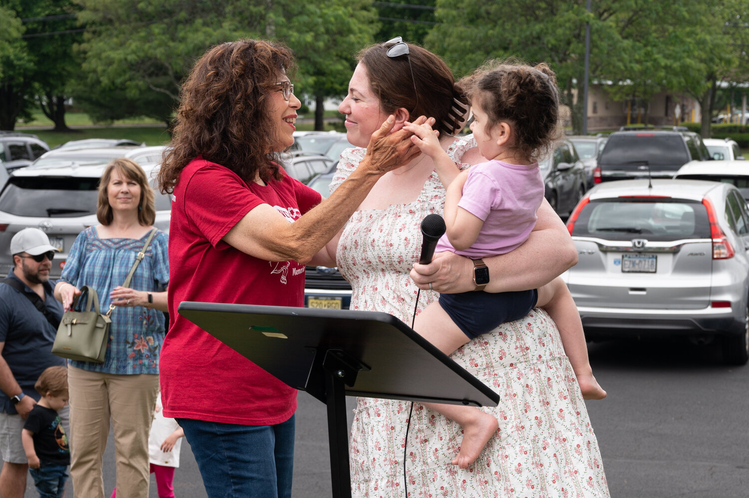 “Miss Marilyn” Schwartz accepts a hug from daughter Catherine Markowitz as her granddaughter Lucy looks on.