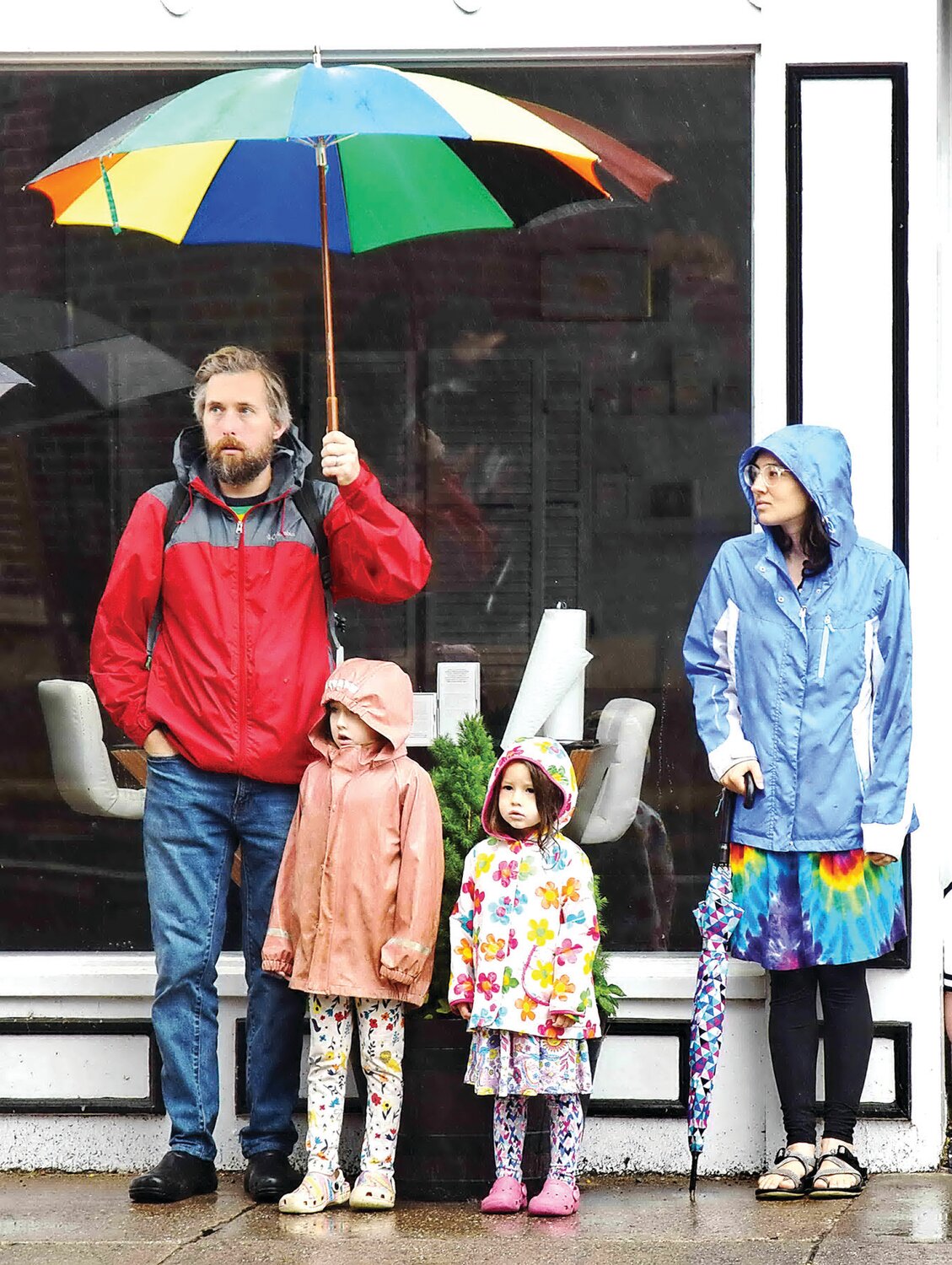 A family braves the rain to attend the PrideFest Parade.