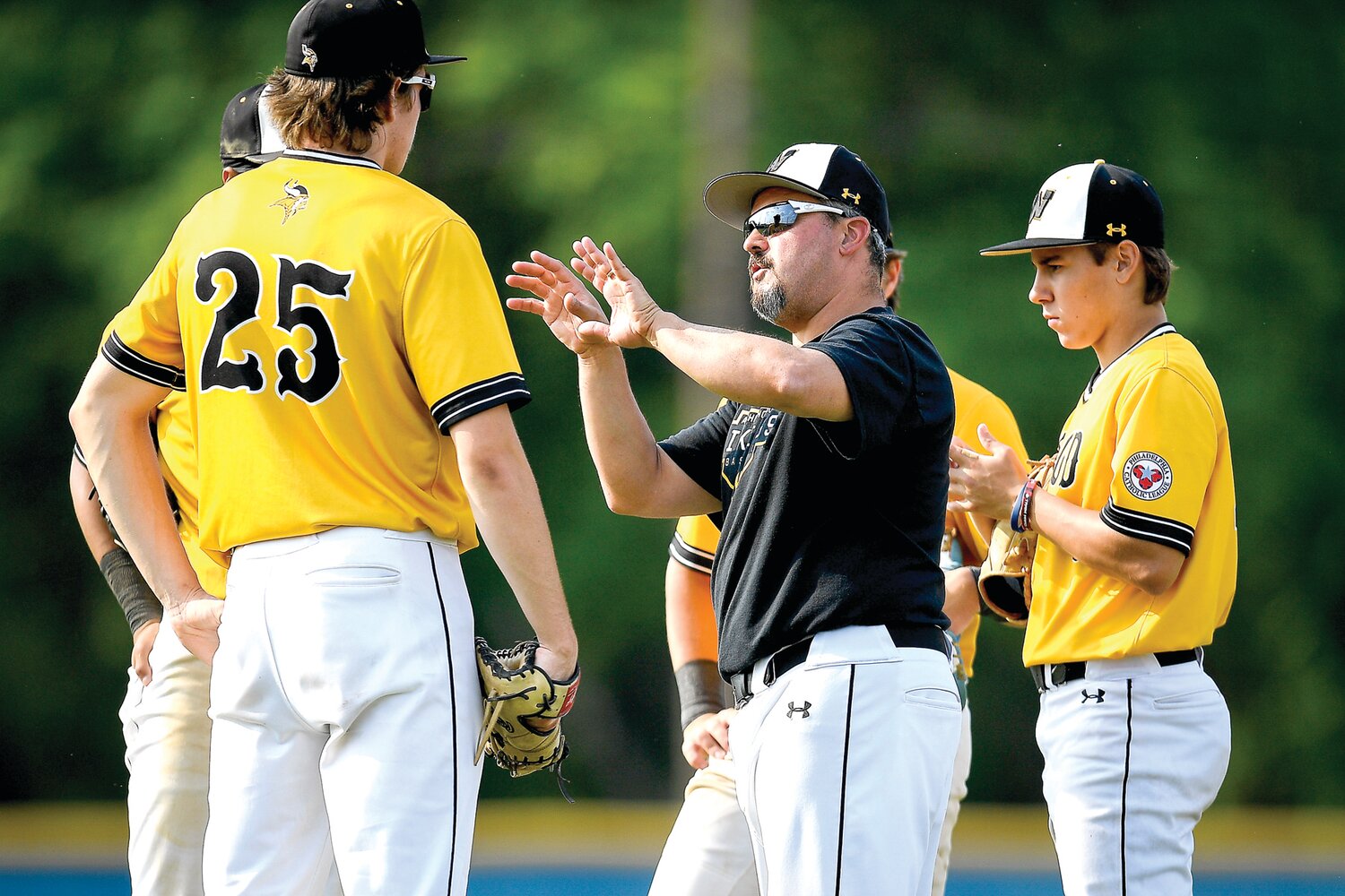Archbishop Wood manager Jim DiGuiseppe Jr. goes over the defense with the infield during a pitching change in the fourth inning.