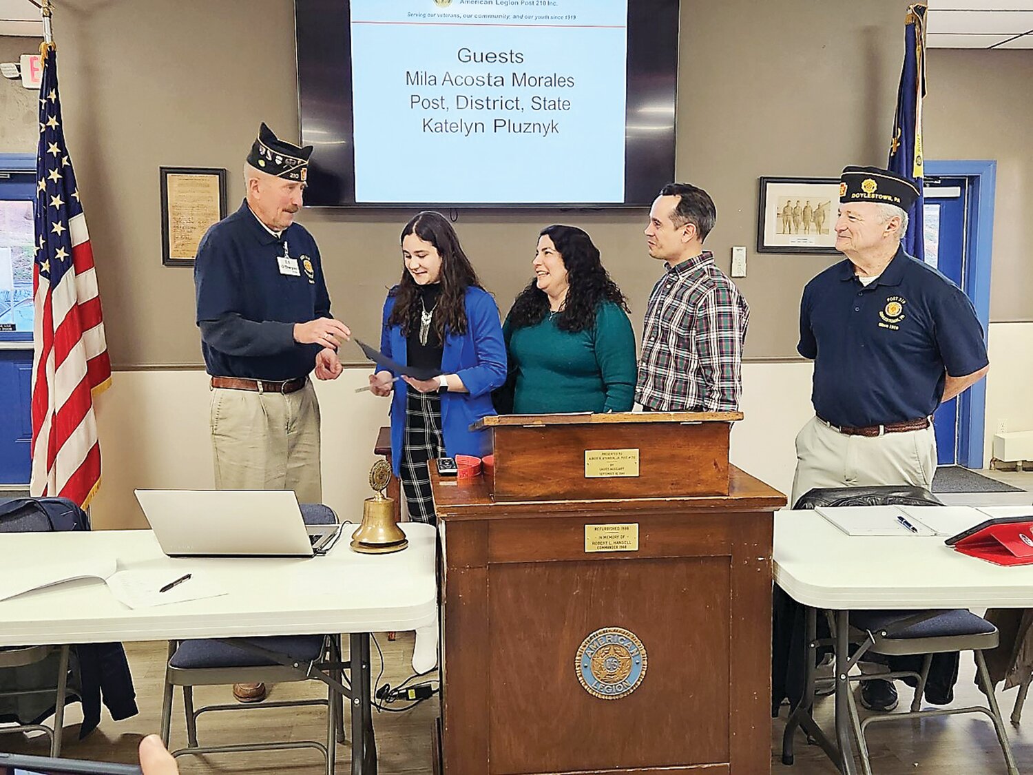 Ed O'Dwyer, American Legion Post 210 finance officer, presents a certificate to Mila Acosta-Morales along with a check for $1,000. Looking on are her Parents, Mirtha and Osvil Acosta-Morales, and Commander Pete Scott.