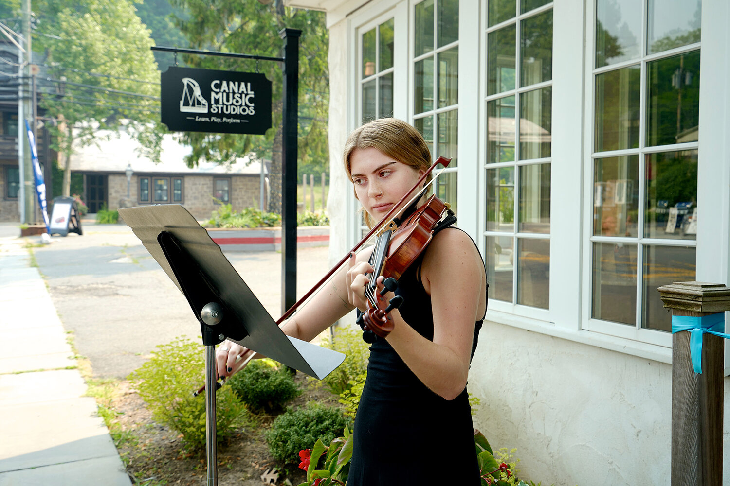 Canal Music Studios student Coco Brown, 19, performs outside of Canal Music Studios on the day of its grand reopening in Stockton. Brown has been playing with CMS founder Adrienne Walsh since she was 7.