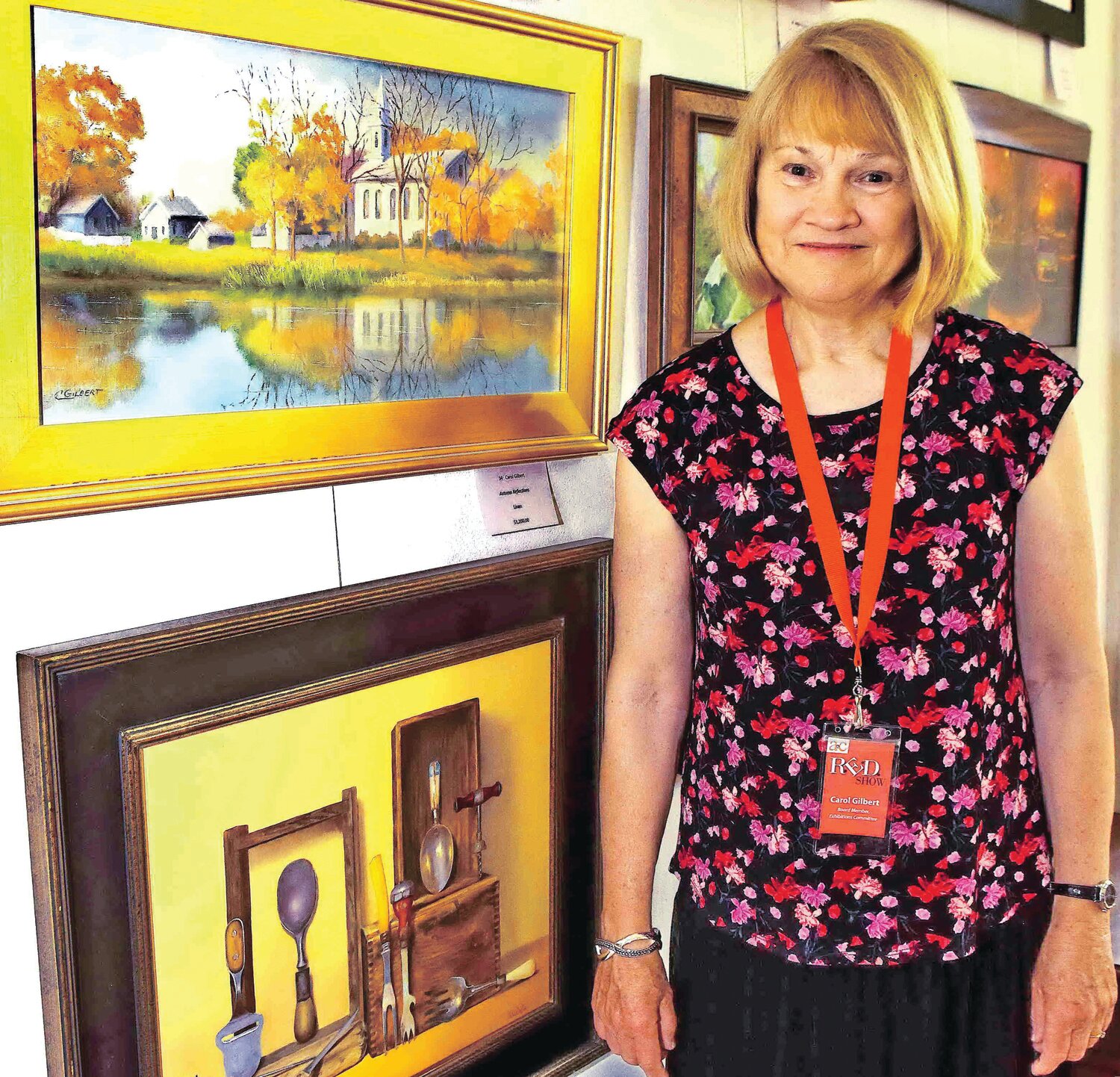 Carol Gilbert stands next to her linen canvas painting, “Autumn Reflections.”