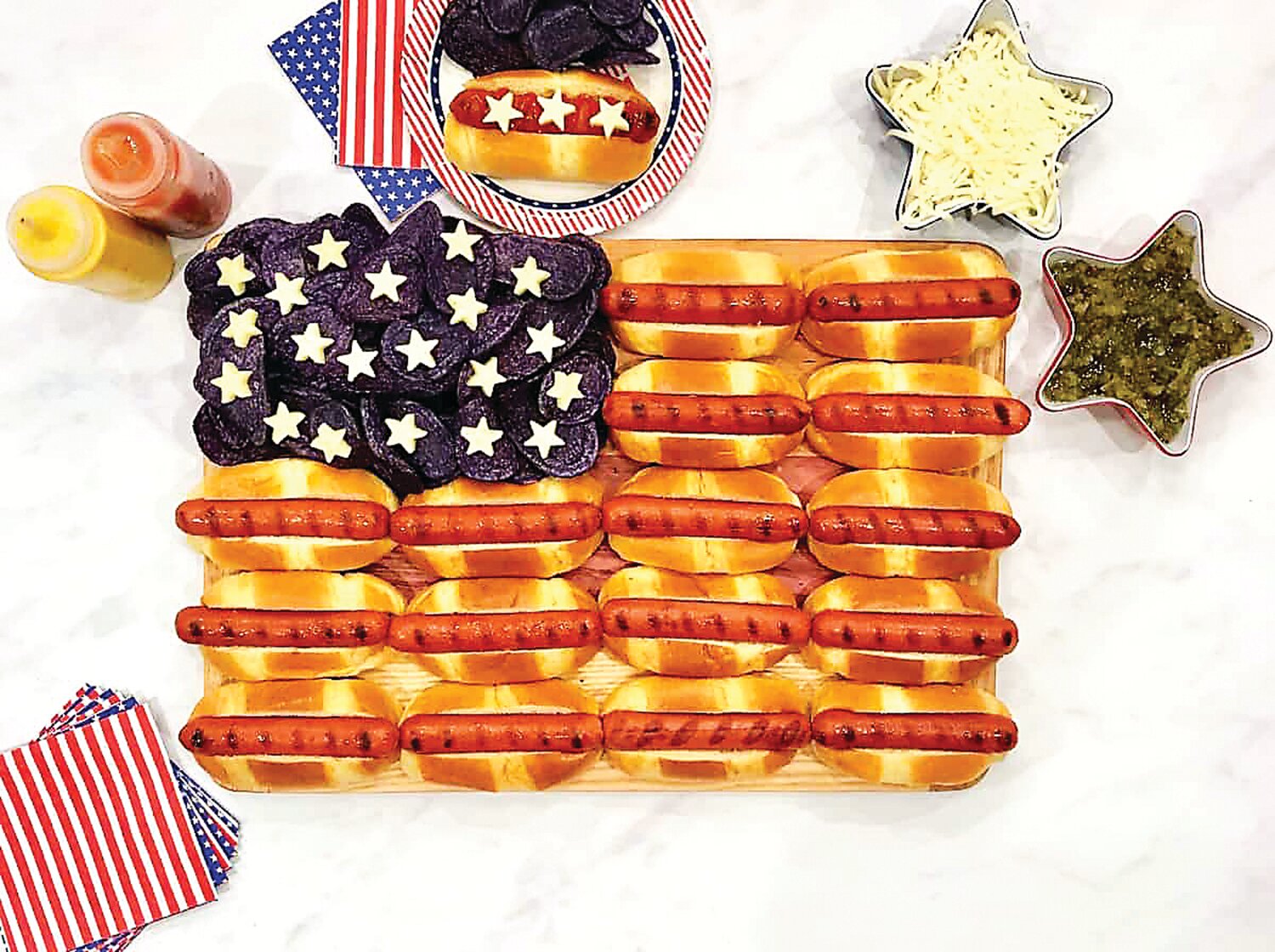 Hurrah for the flag on the Fourth of July.  There are many ways you can display food with a patriotic theme for the holiday; this one is hot dogs, blue corn chips and stars cut from slices of cheese.