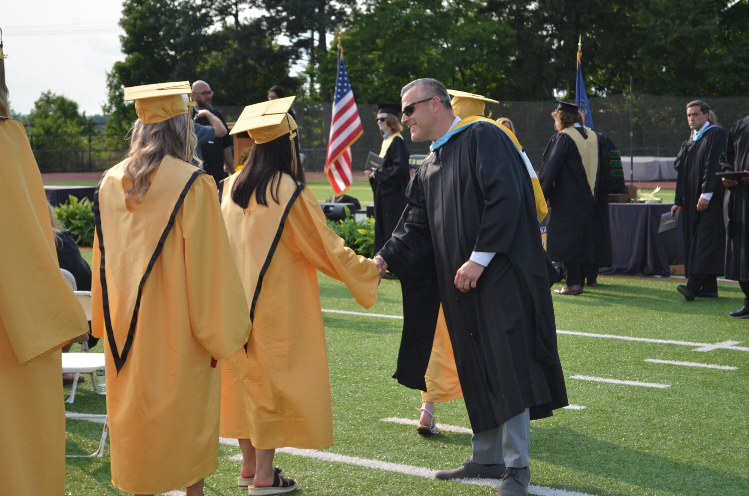 CB West Assistant Principal Frank Pustay greets graduates as they step forward to receive their diplomas.