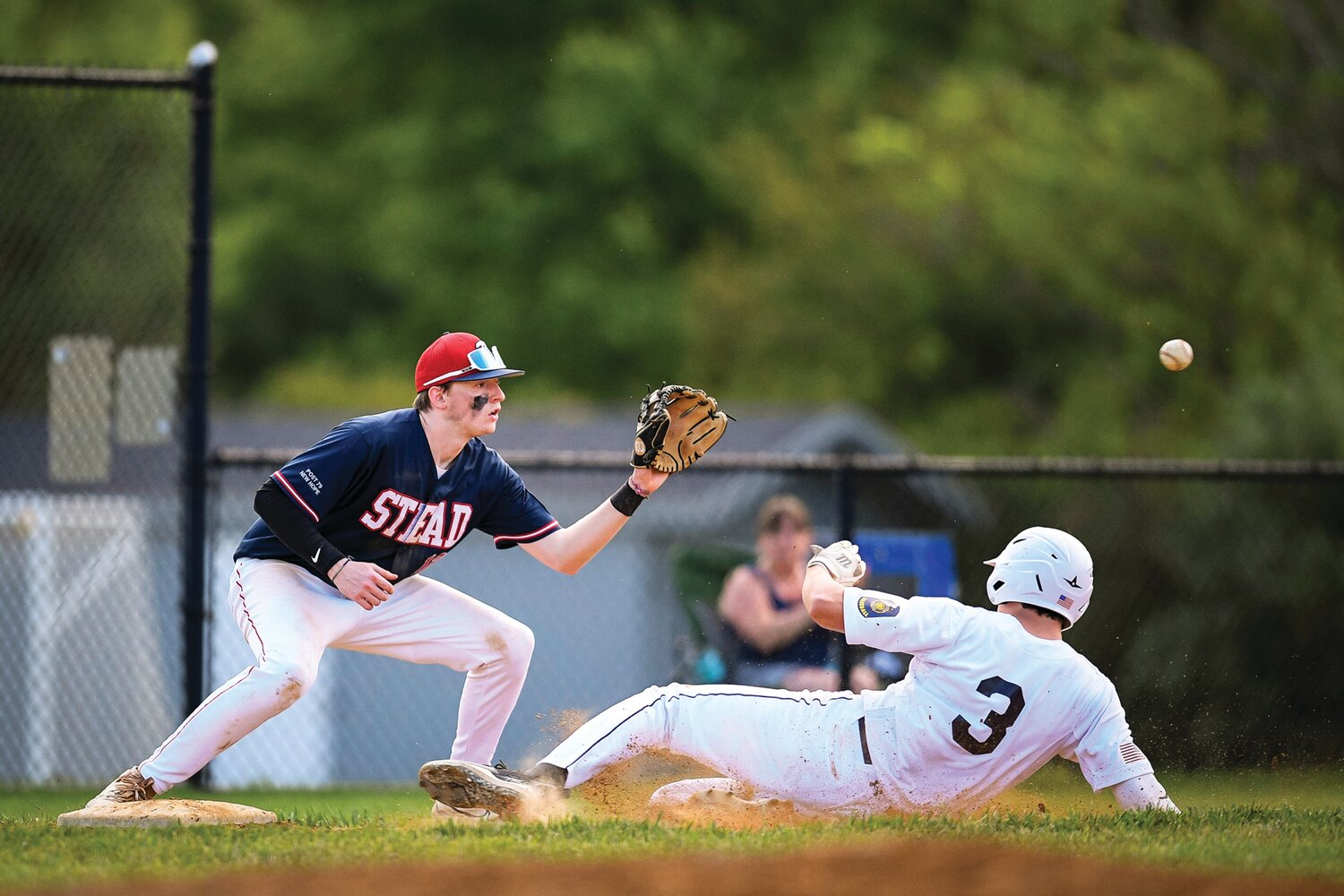 Doylestown’s Connor Grzywacz slides in ahead of the throw with a triple as Plumstead’s Chase Kimbel waits for the ball.