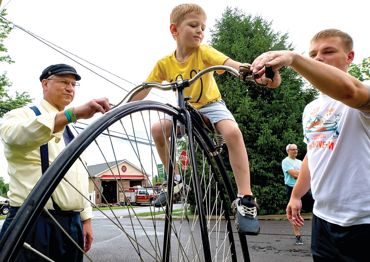 Bill Soloway, left, of The Wheelmen, lets 5-year-old Alex Tomakh sit atop an antique high wheel bike.