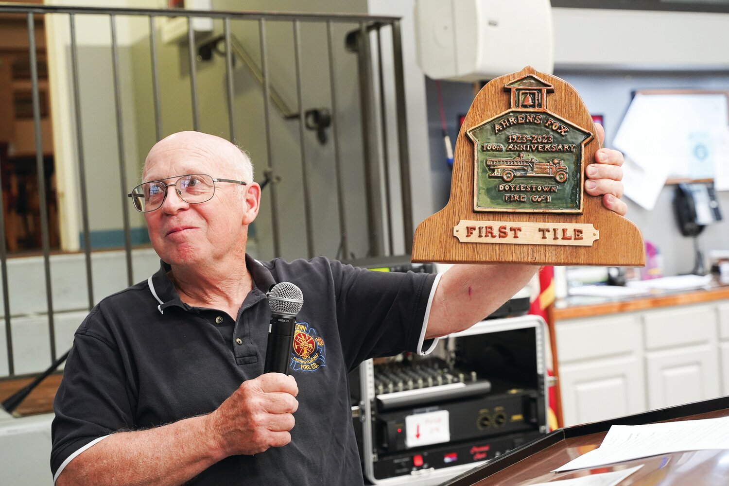 Bill Price, a 52-year firefighter, shows off a tile commemorating the Ahrens Fox pumper’s centennial with Doylestown Fire Co. #1. Price chaired the department’s recent “Old Timers Night,” which recognized the contributions of longtime members.