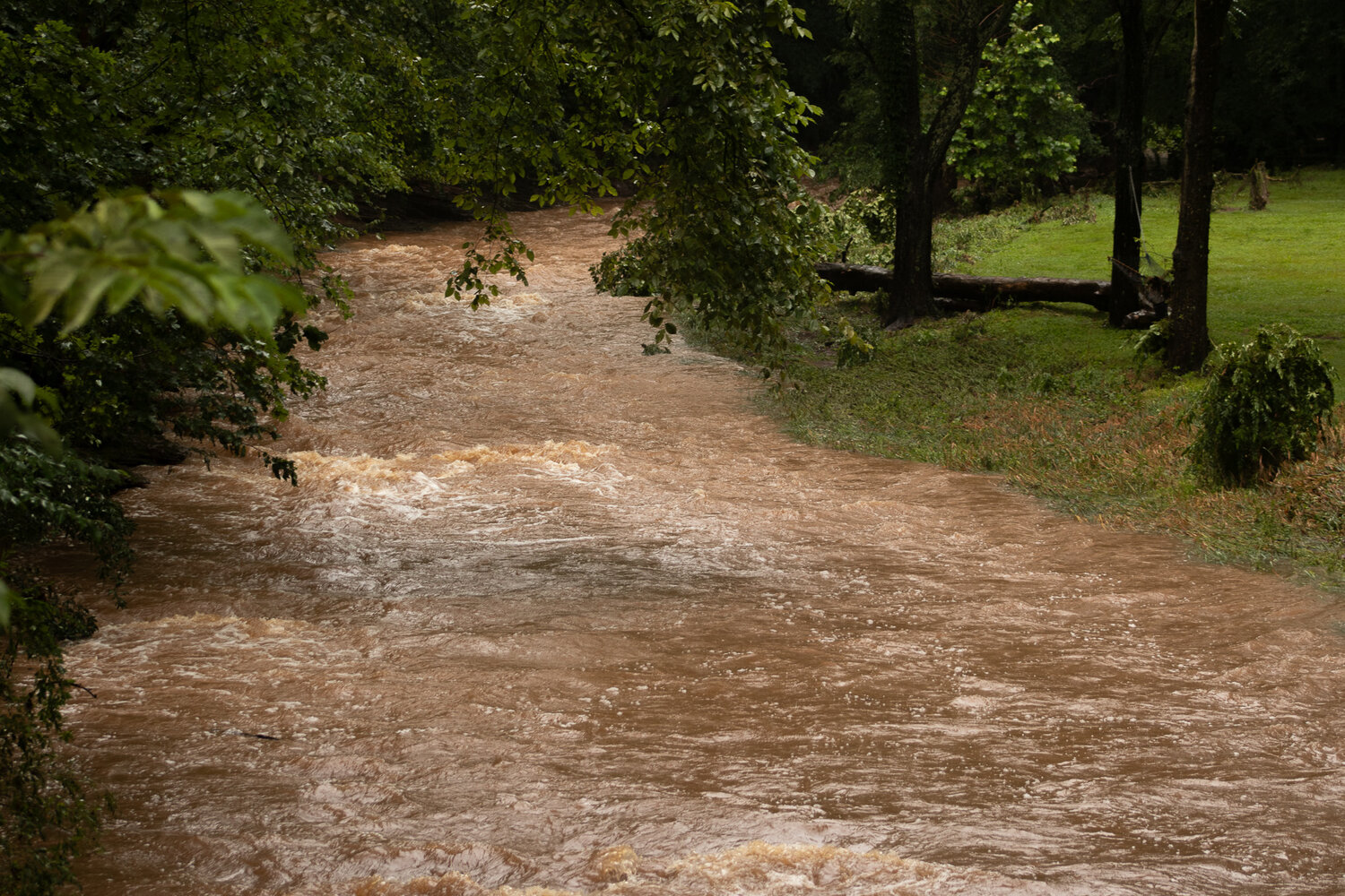 Twelve hours after Saturday’s flash flood along the Houghs Creek in Upper Makefield, the water still rages near the area where five people died Saturday.