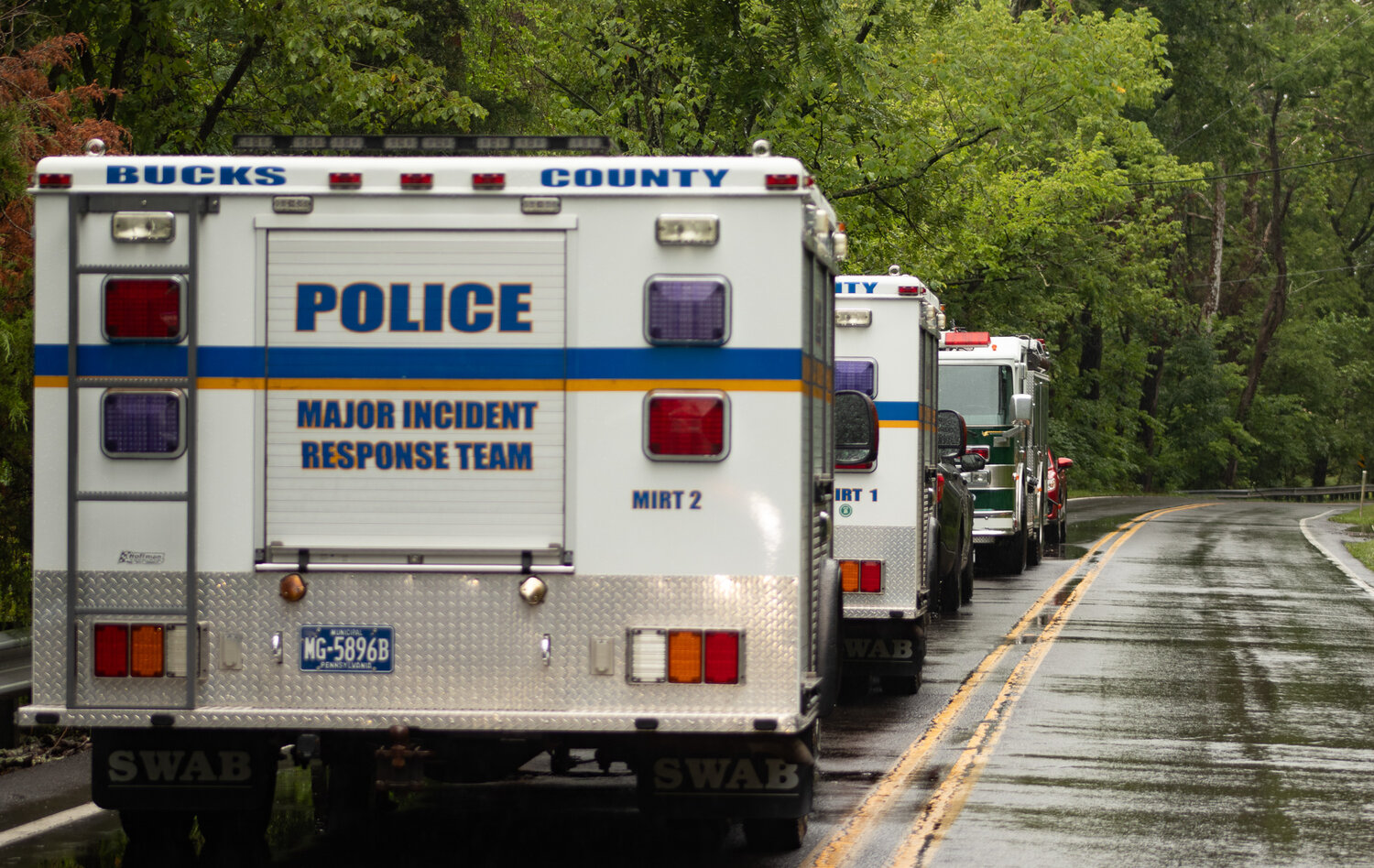 Bucks County first responders’ vehicles line the road near a flooded out area of Upper Makefield Sunday.