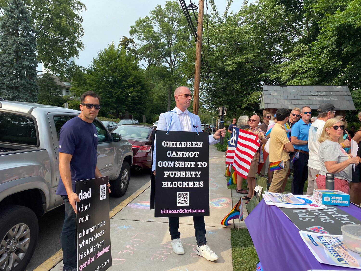Wearing a sandwich board and holding a recording device, “Billboard Chris” Elston protests “puberty blockers” in front of Salem United Church of Christ in Doylestown, where Rainbow Room meetings are held.