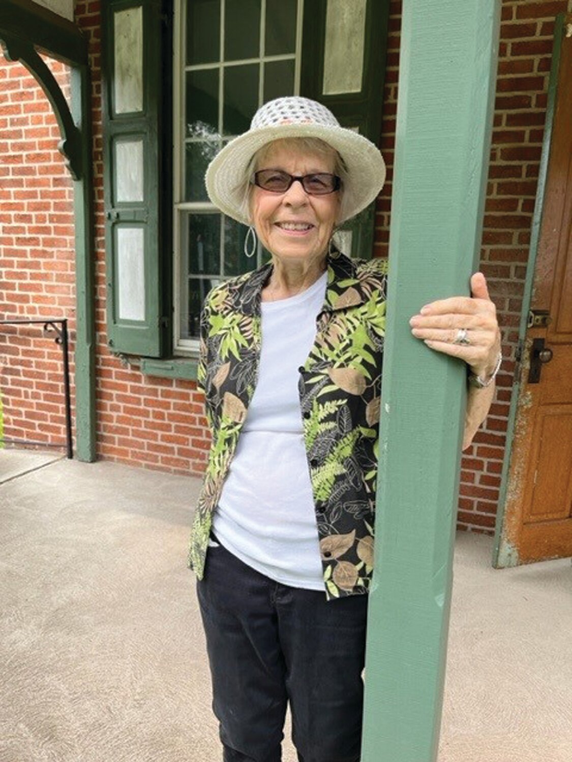 Sandy Shelly stands at the 1885 one-room school named for her family. An ancestor donated the one-third acre on which it stands.