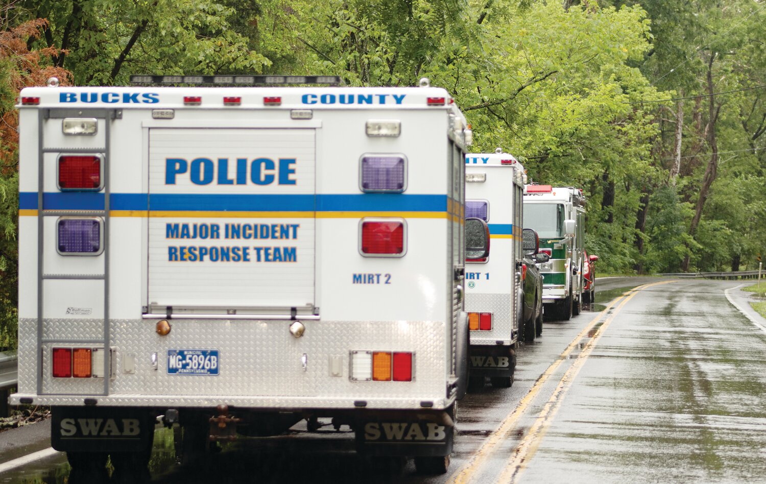 Bucks County first responders’ vehicles line the road near a flooded out area of Upper Makefield Sunday.