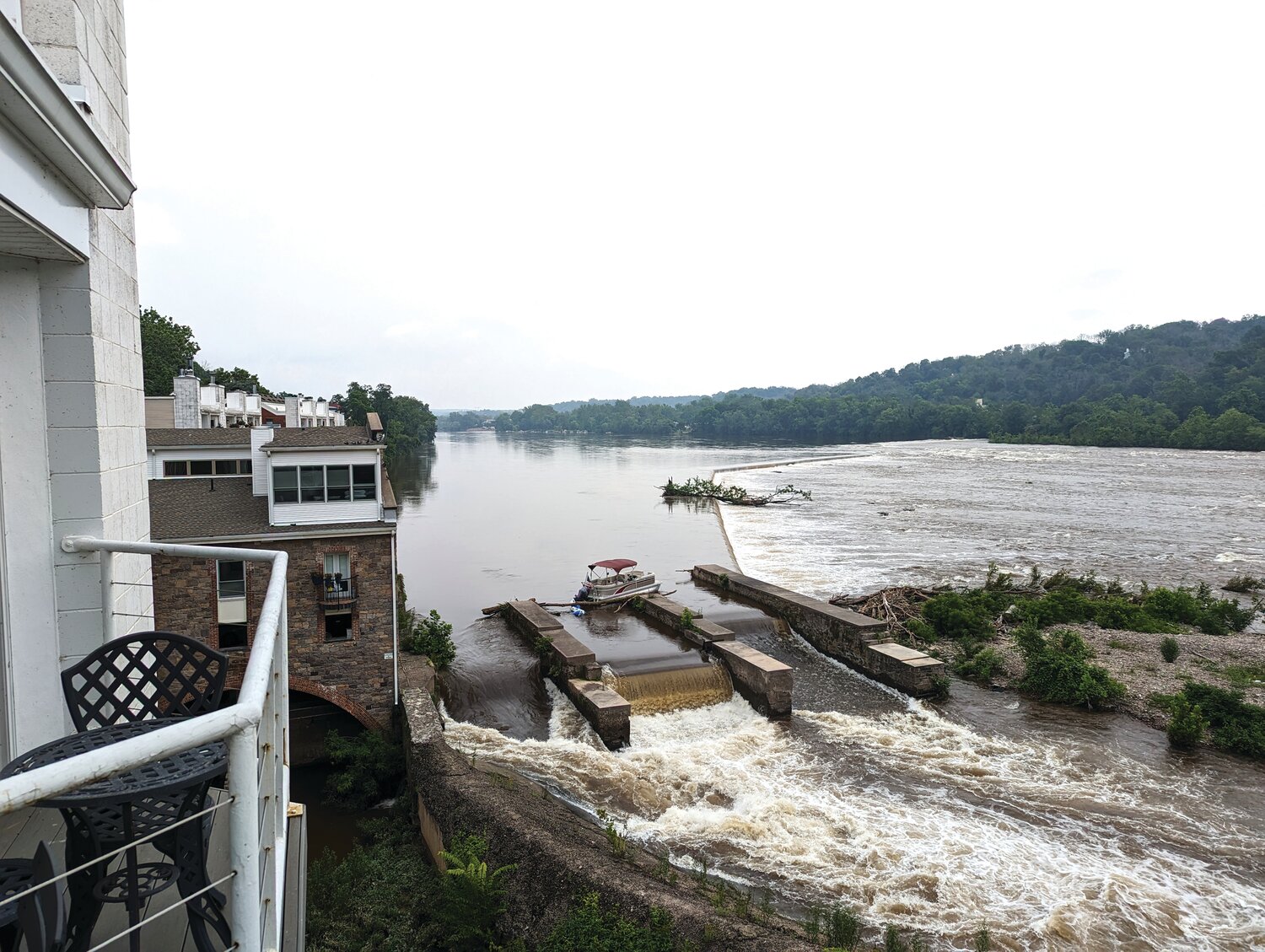 A pontoon boat set adrift by the weekend’s storm and flood sits idle on at the New Hope Wing Dam on the Delaware River in front of the Waterworks Condominiums.