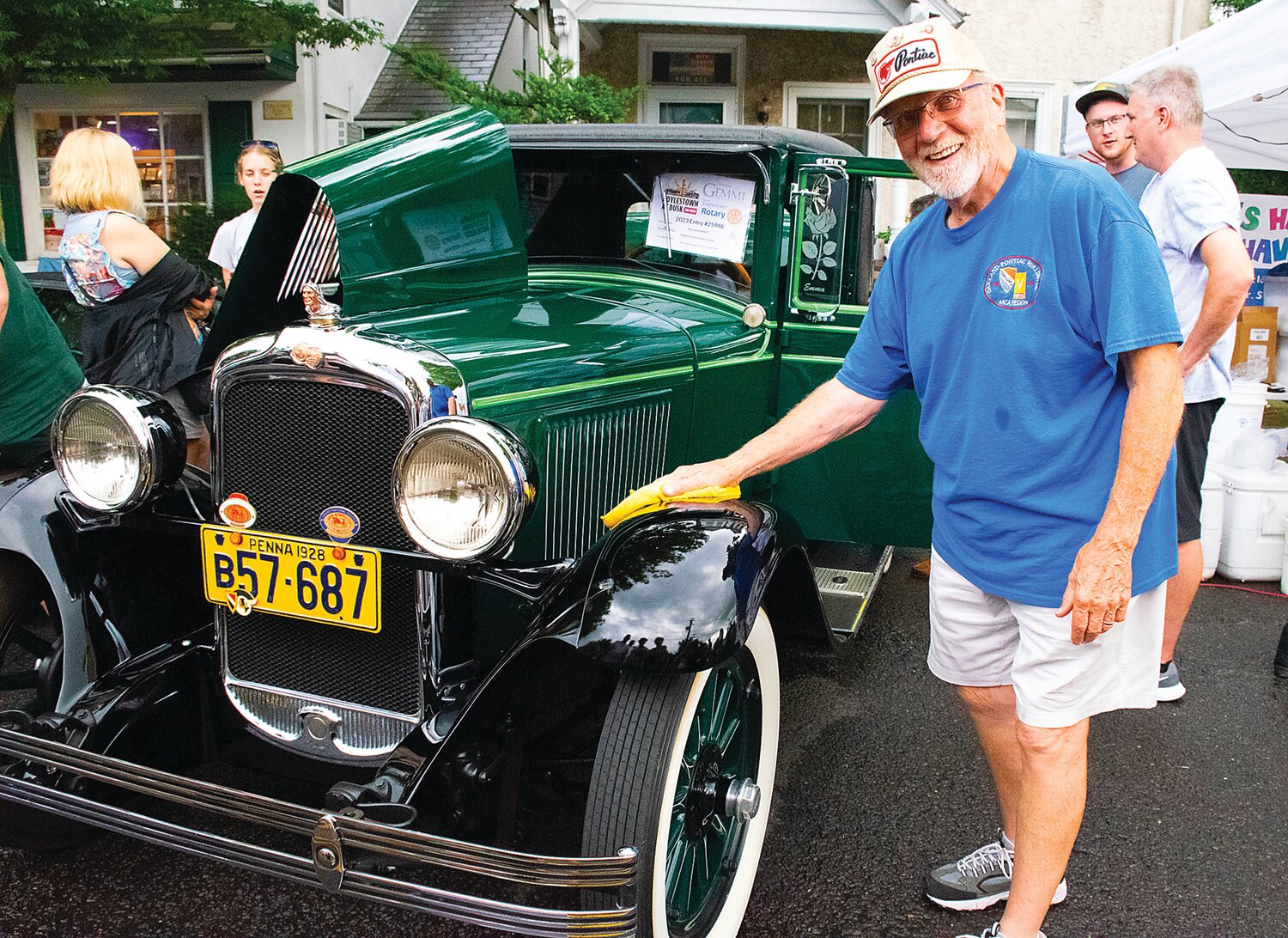 Terry Schweikert wipes his 1928 Pontiac Landau Coupe clean after the rain. The vehicle won a Top 40 Award.