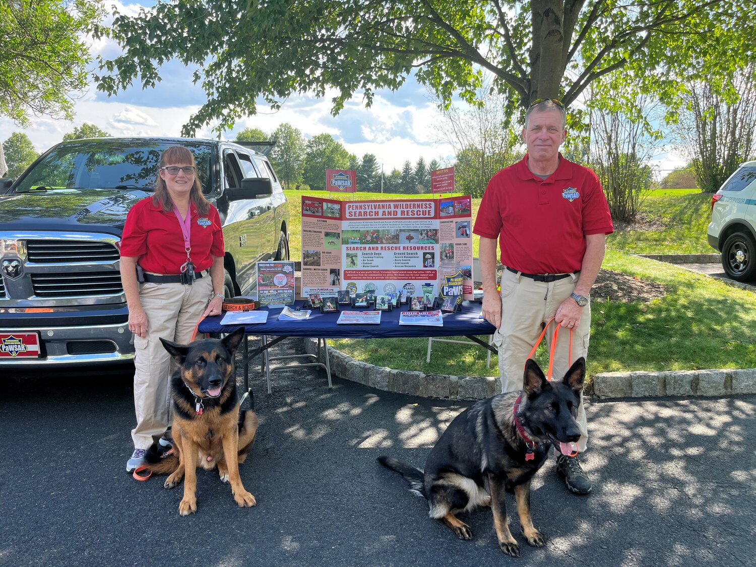 Representatives of Pennsylvania Wilderness Search and Rescue — PAWSAR — man the organization’s table at Doylestown Township’s National Night Out event Tuesday at Central Park.