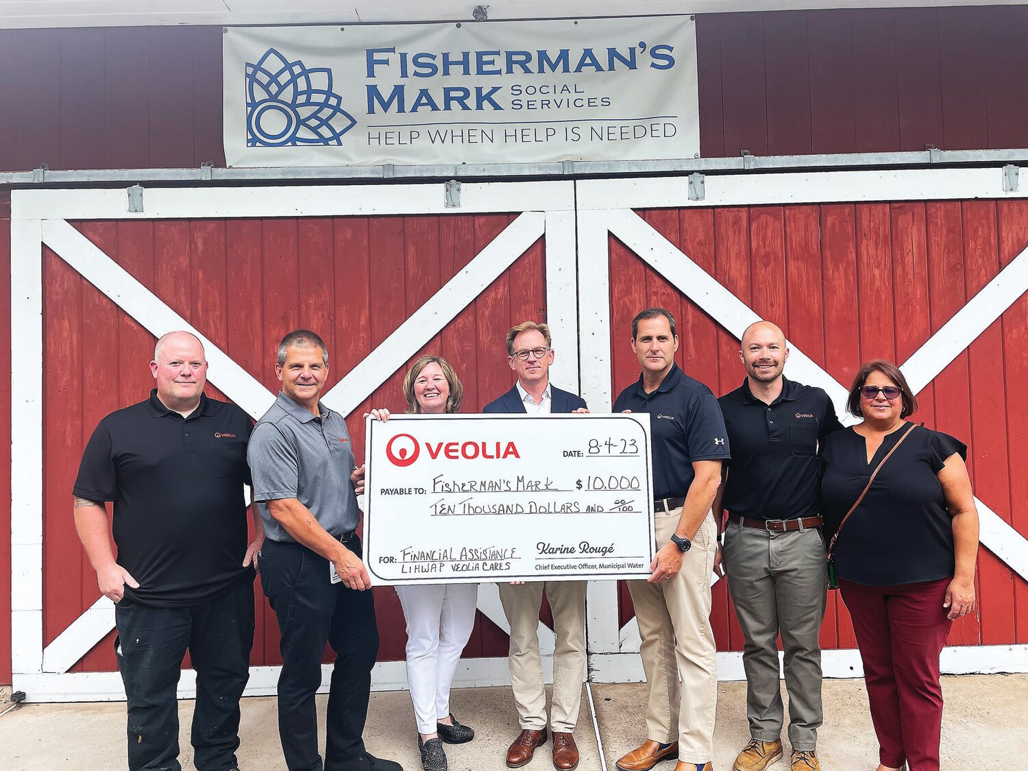 Veolia Water presents Jennifer Williford, executive director of Fisherman's Mark, center, and Lambertville Mayor Andrew Nowick,center, with a $10,000 check.
