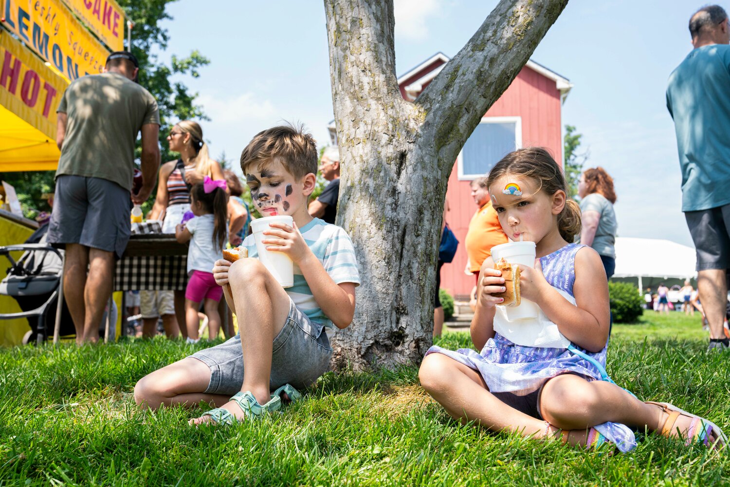 Clayton and Lily Sharp take shade while snacking on the many food options provided at Peddler’s Village’s 2023 Peach Festival.
