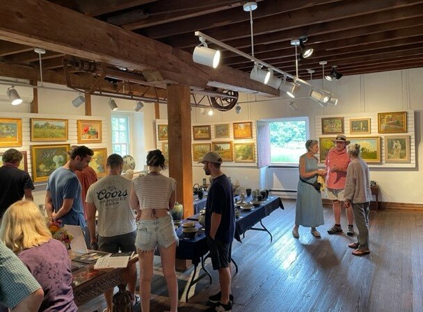 Visitors get a look at some of the 50 paintings by Dot Bunn and stoneware by Willi Singleton.
