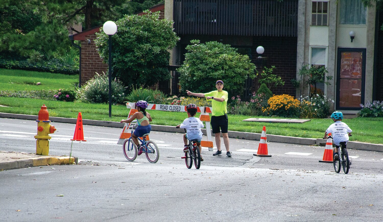 A volunteer shows a trio of riders the way.