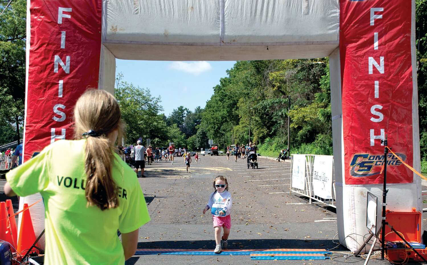 A volunteer watches as Abigail Keenan toes the finish line.