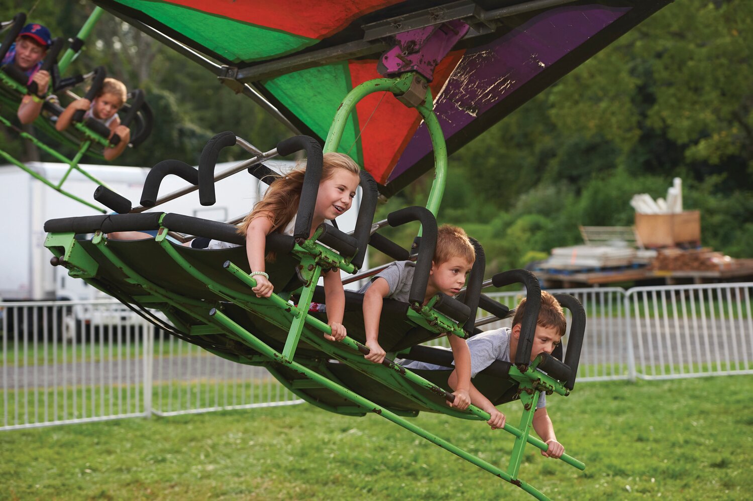 Lucy Jacobs, 8, with her 5-year-old brother, Sammy, and Benjamin Boscoe, 7, on the Cliff Hanger at the Middletown Grange Fair in Wrightstown Aug. 17.