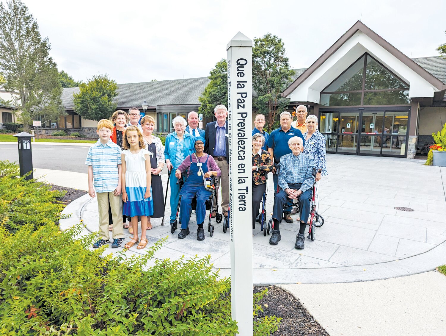 Participants observe the rededication of the  Peace Pole at Pennswood Village.