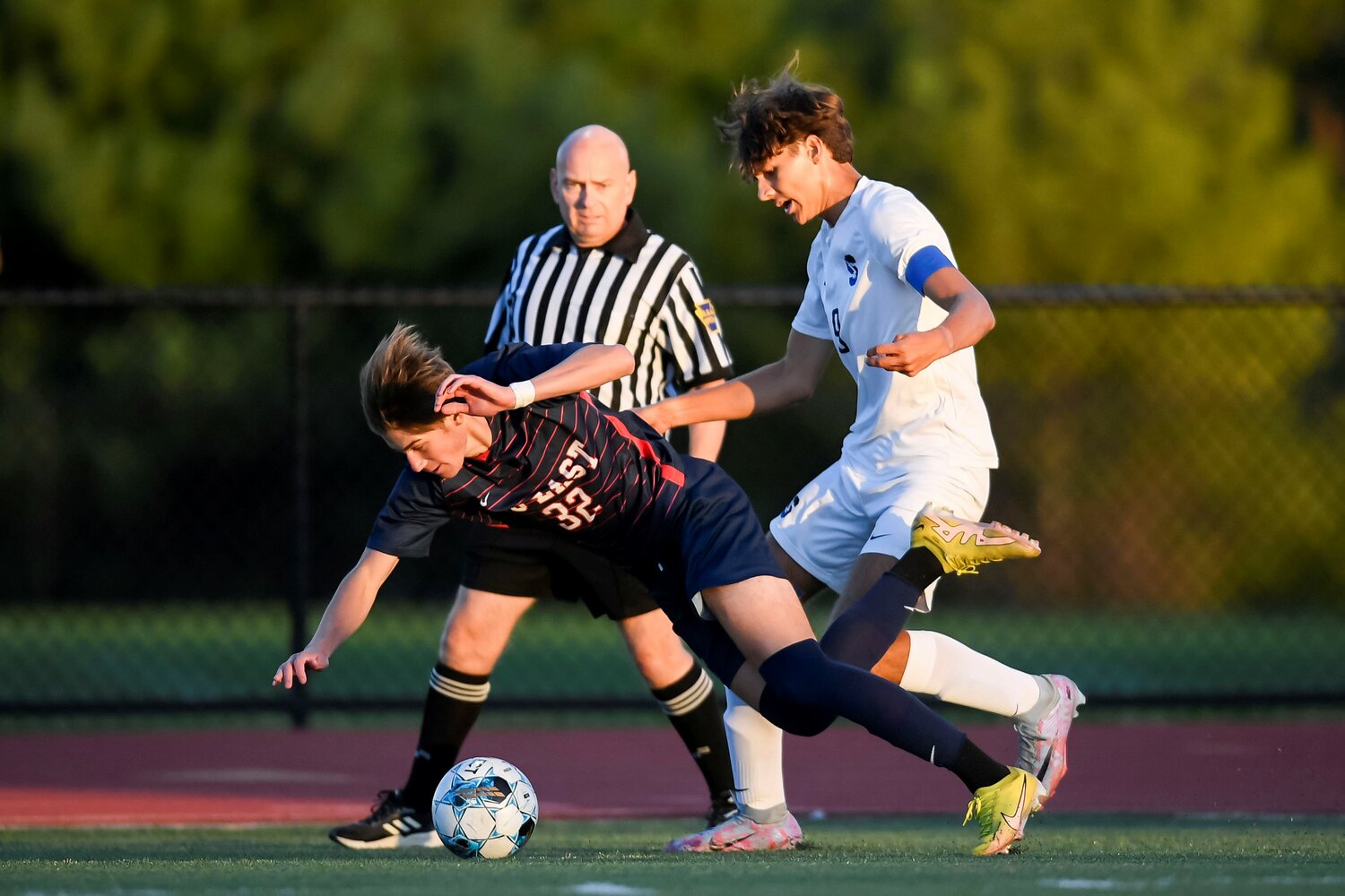 Central Bucks South’s Pat Chrzanowski trips Central Bucks East’s Nick Raysky during the first half of East’s 3-0 win.