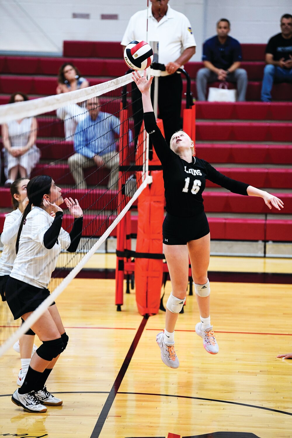 Faith Christian’s Aubrey Pringle just gets enough to tip the ball over for a point in the third match.