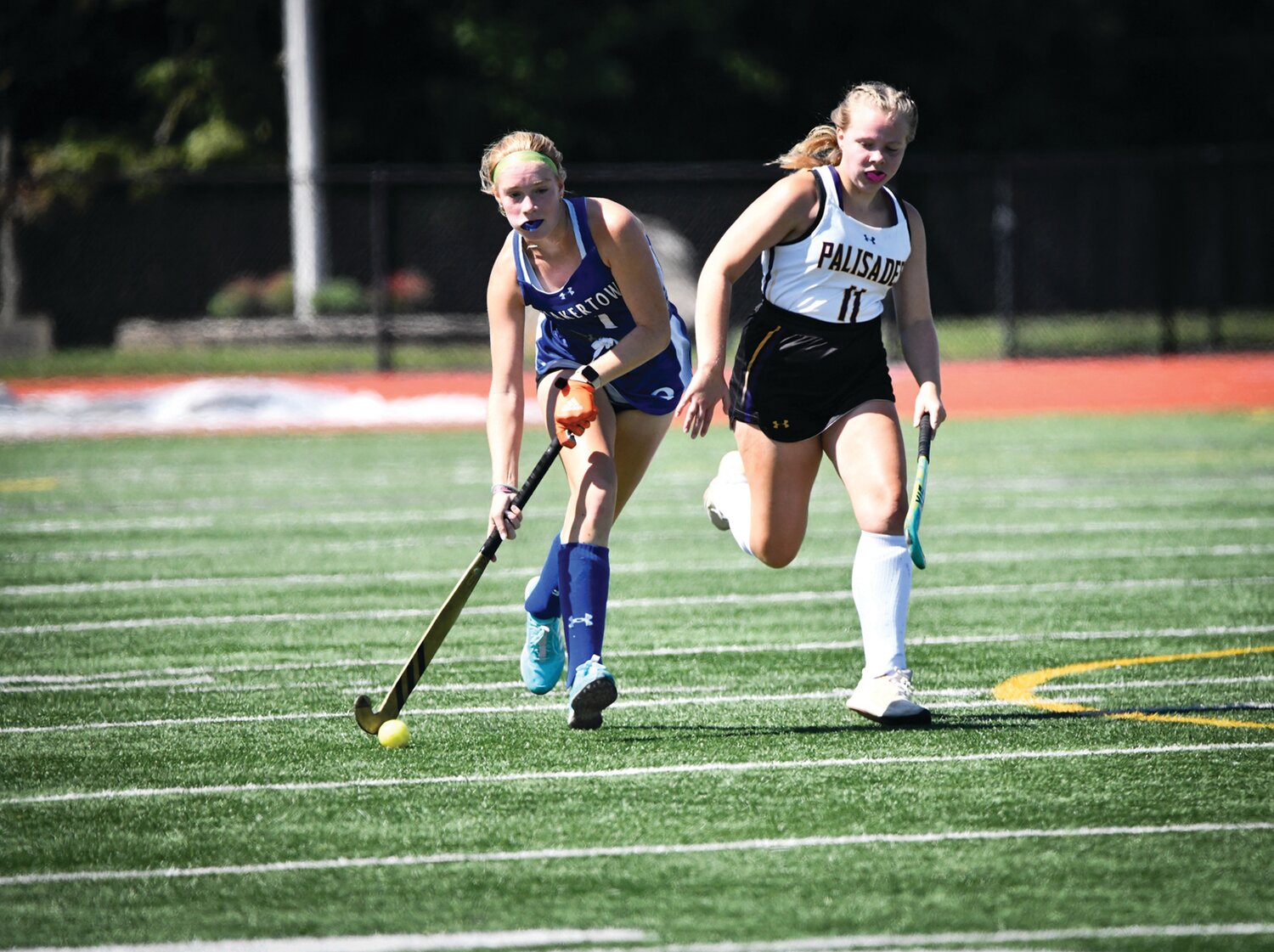 Quakertown’s Sunday Draper moves the ball down the field with Palisades’ Molly Stiansen in pursuit.