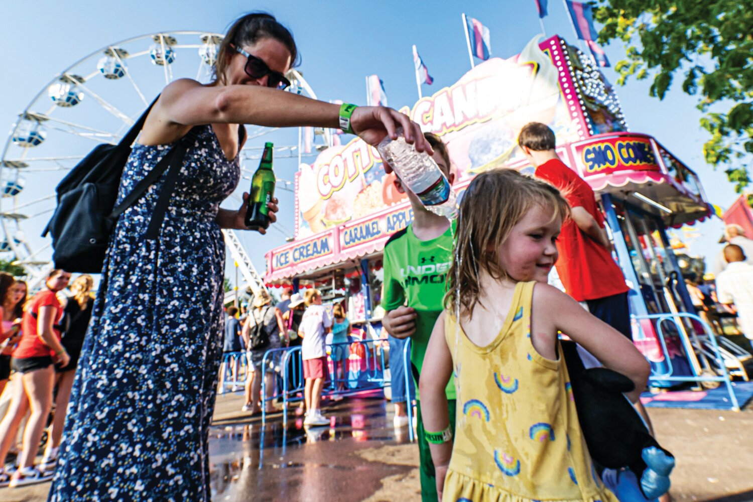 A mother drips some water on her daughter to help her cool off as temperatures soared into the 90s during the 57th annual Polish American Family Festival & Country Fair 2023 Sunday.
