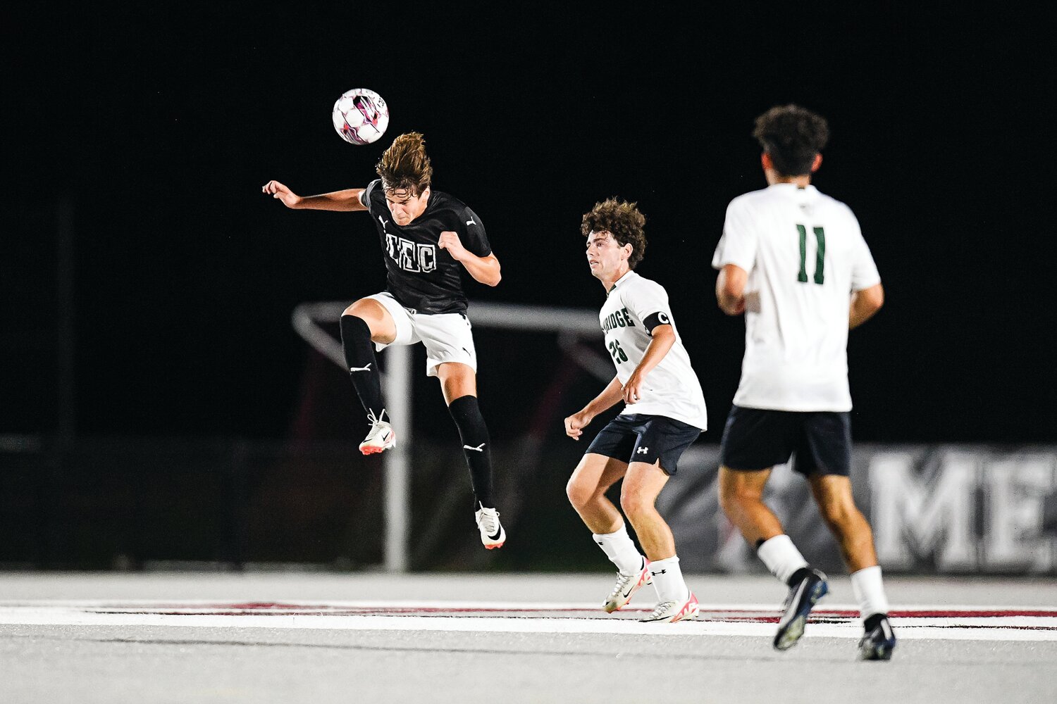 Faith Christian’s Jude Clymer clears the zone by heading the ball out ahead of Pennridge’s Patrick Fannon and Chase Rabinowitz.