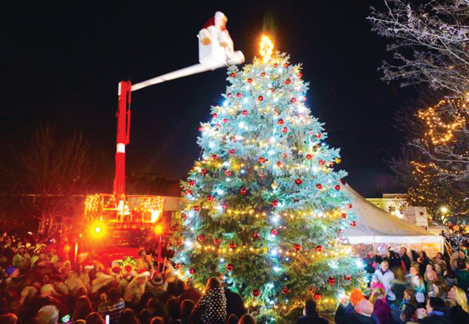 Santa Claus lights the Perkasie Borough Christmas tree, as its light gives a luster of midday to objects below.