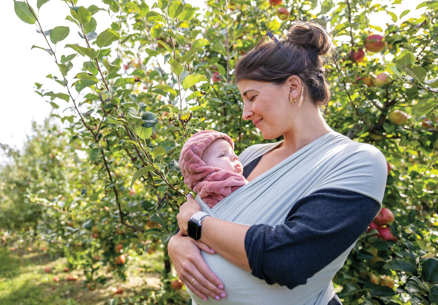 Allie Dinesen cradles her newborn while her family picks apples at Solebury Orchards Saturday afternoon.