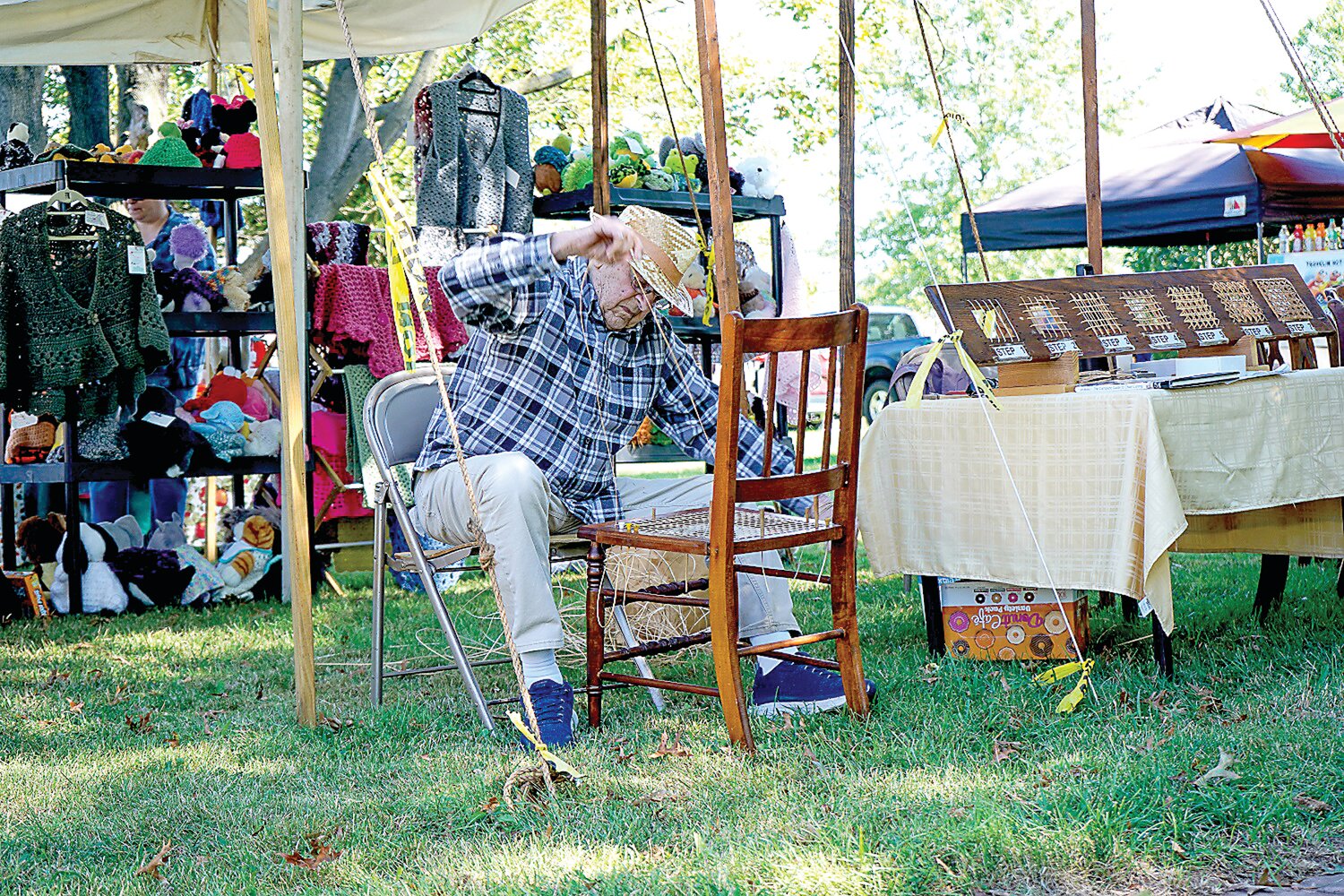 Edward B. Tice works on a wicker chair.