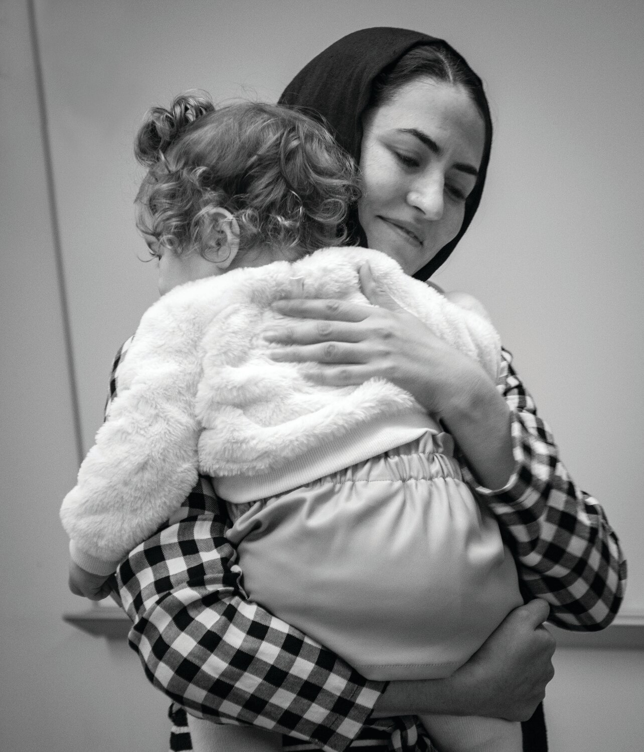 Shabana Abedy, a childcare worker, holds Asel Bayram while the little girl’s mother Derya Bayram takes part in a Family Literacy class at Vita’s Levittown location.